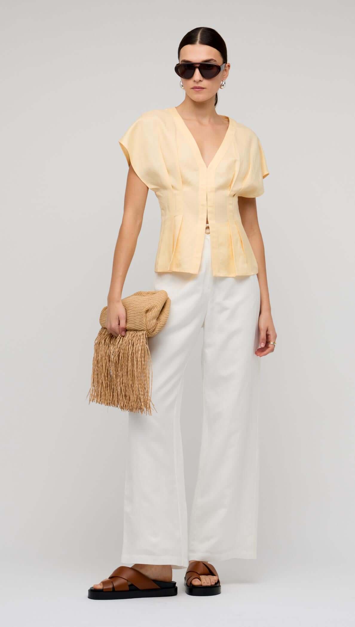 Butter Yellow Linen Pleated Blouse worn by a model showcasing its deep V-neckline and sculpted pleats.