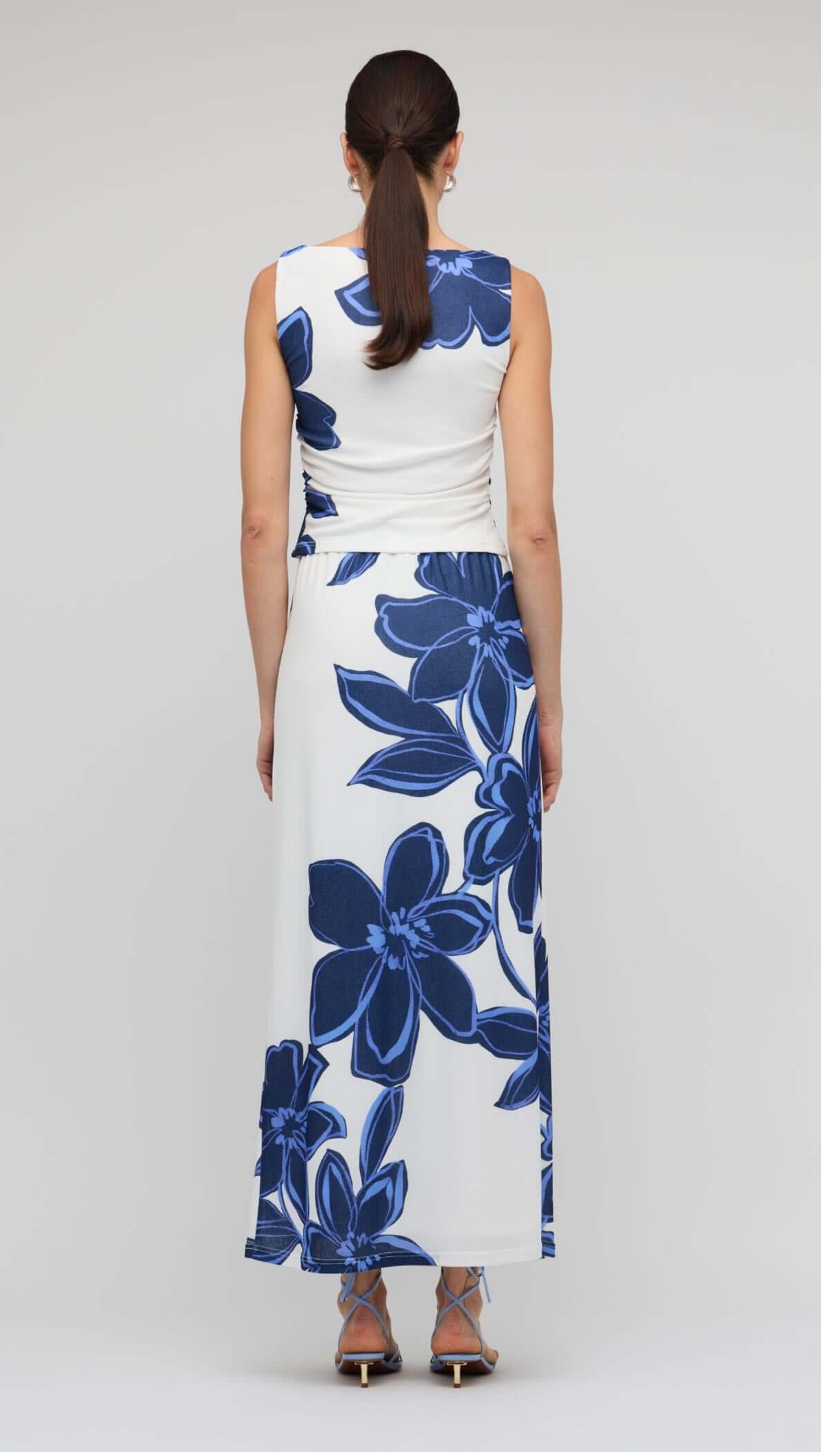 Blue & White Floral Mesh Top featuring a sleeveless design and oversized floral print, styled with a maxi skirt.