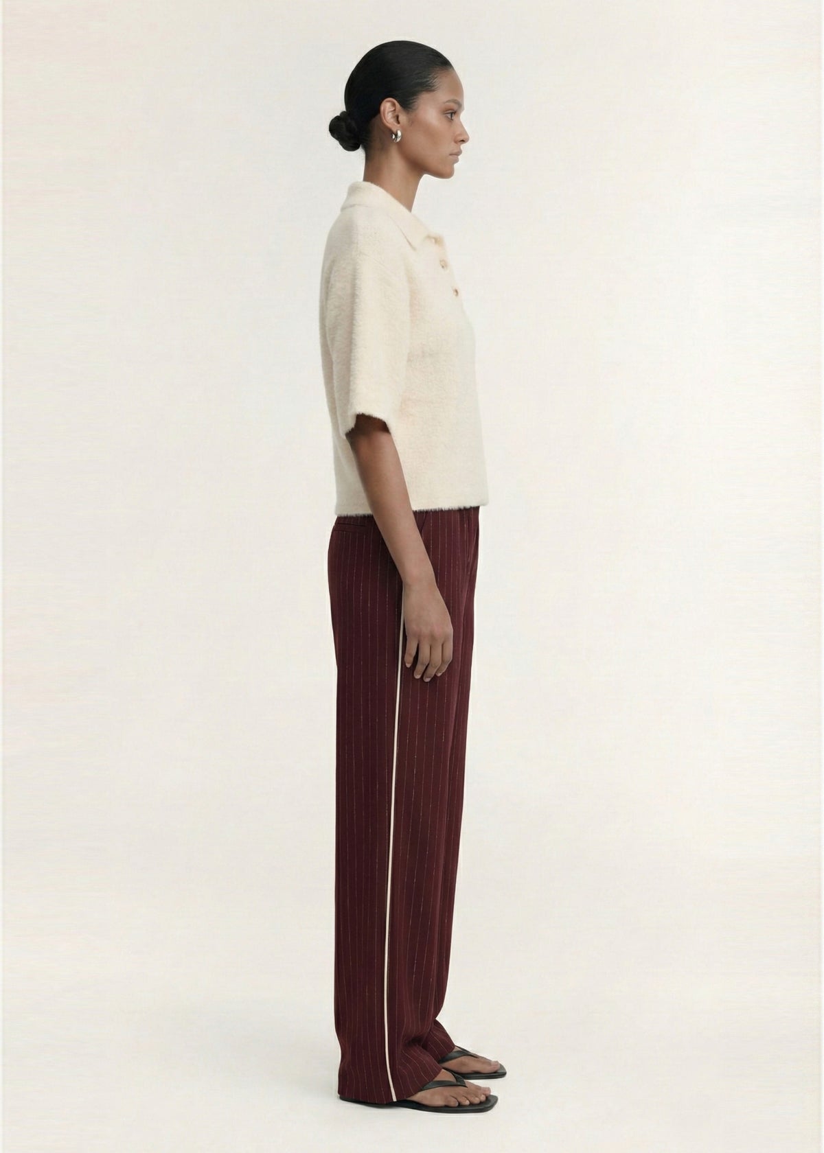 Model wearing Fluffy Knit Polo Top in Cream with a soft textured knit fabrication and a relaxed fit silhouette, turned to the side.