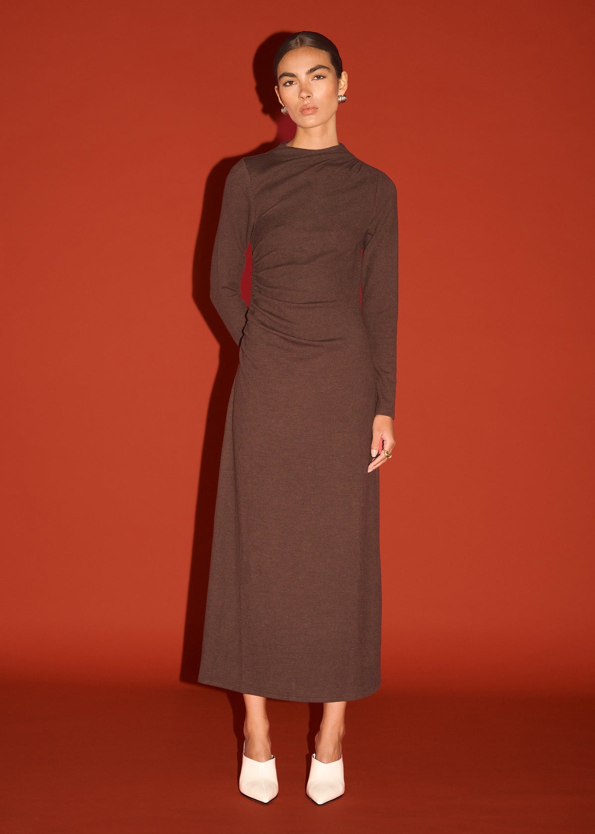 Model wearing Gather Detail Long Sleeve Jersey Midi Dress in Chocolate, showing a subtle side ruching detail and a high neckline.
