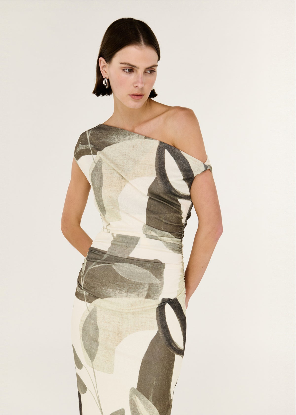 Model wearing Green Leaf Off Shoulder Midi Dress with an all-over Light Leaf Garden print and a fully lined, turned to the side.