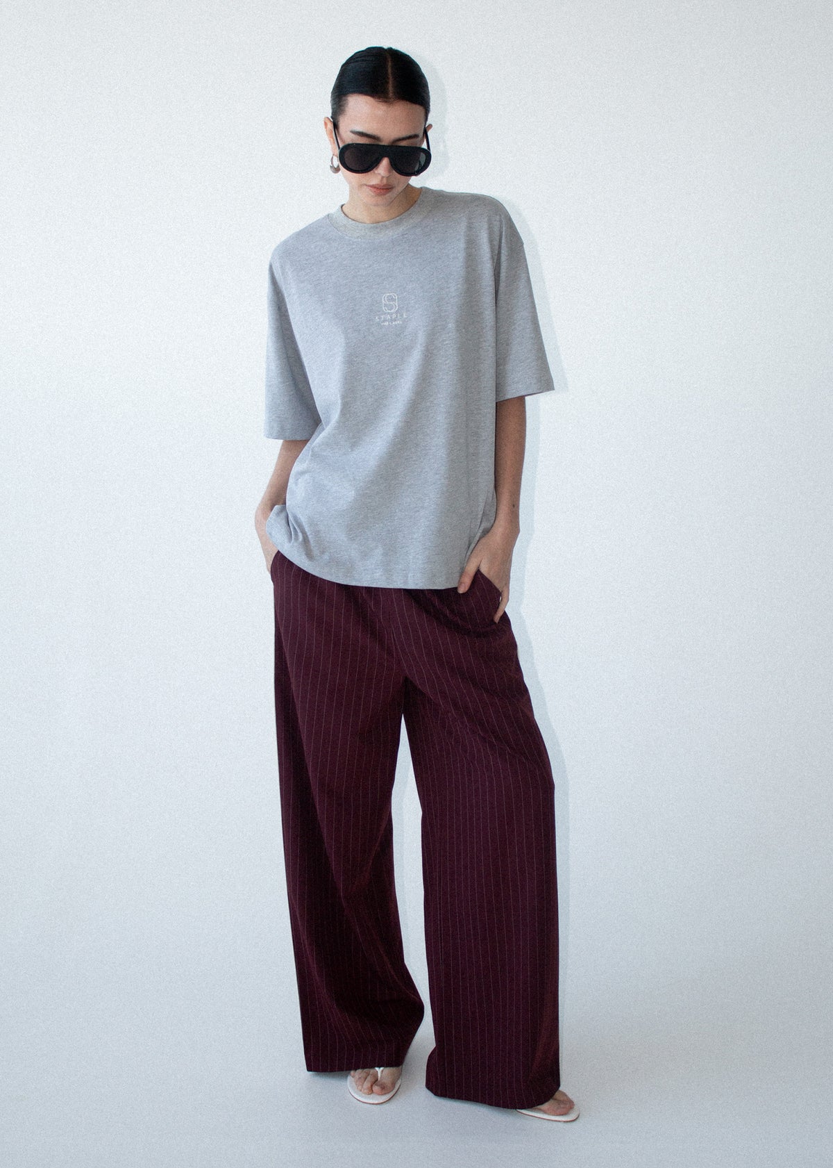Model wearing Grey Marle Cotton Embroidered Oversized Tee with dropped shoulder seams and short sleeves.