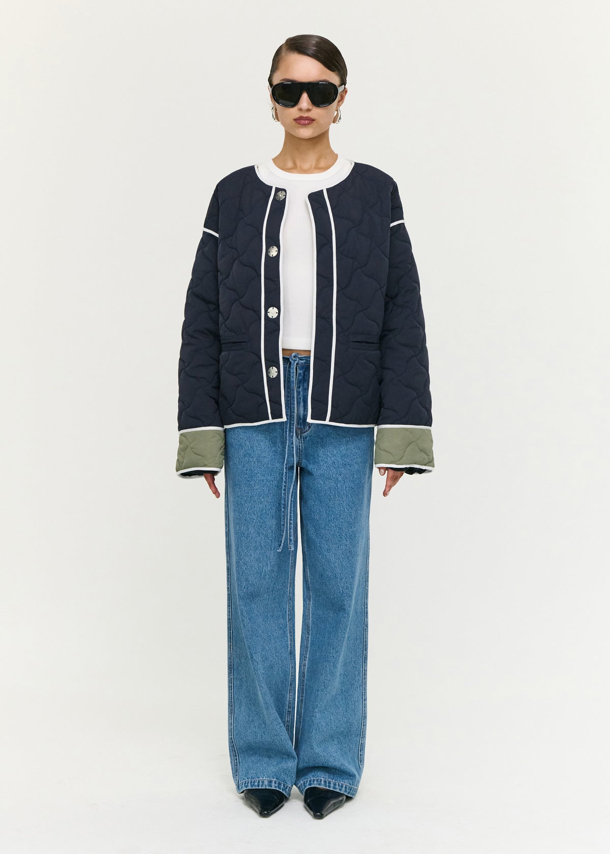 Model wearing Hollis Puffer Jacket, showing a contrast binding detailing and long sleeves with contrast cuff panels.
