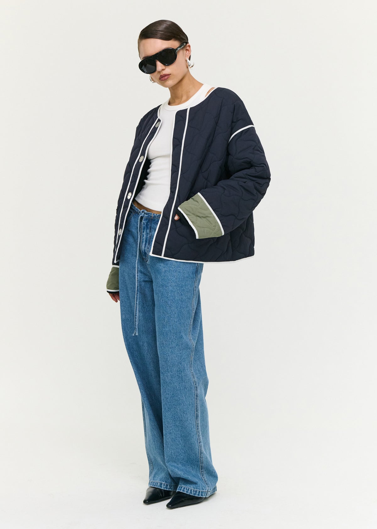 Angled view of the Hollis Puffer Jacket with a round neckline and an oversized snap button front closure.