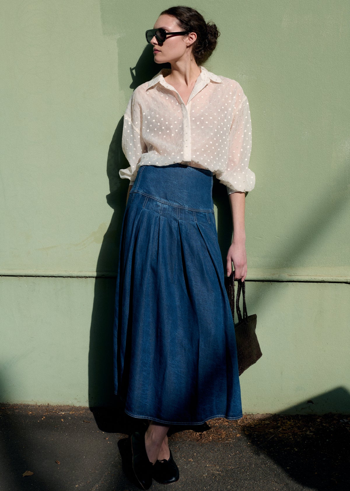 Model wearing Indigo Chambray Box Pleat Midi Skirt, showing a box pleat detail and a full A-line silhouette.