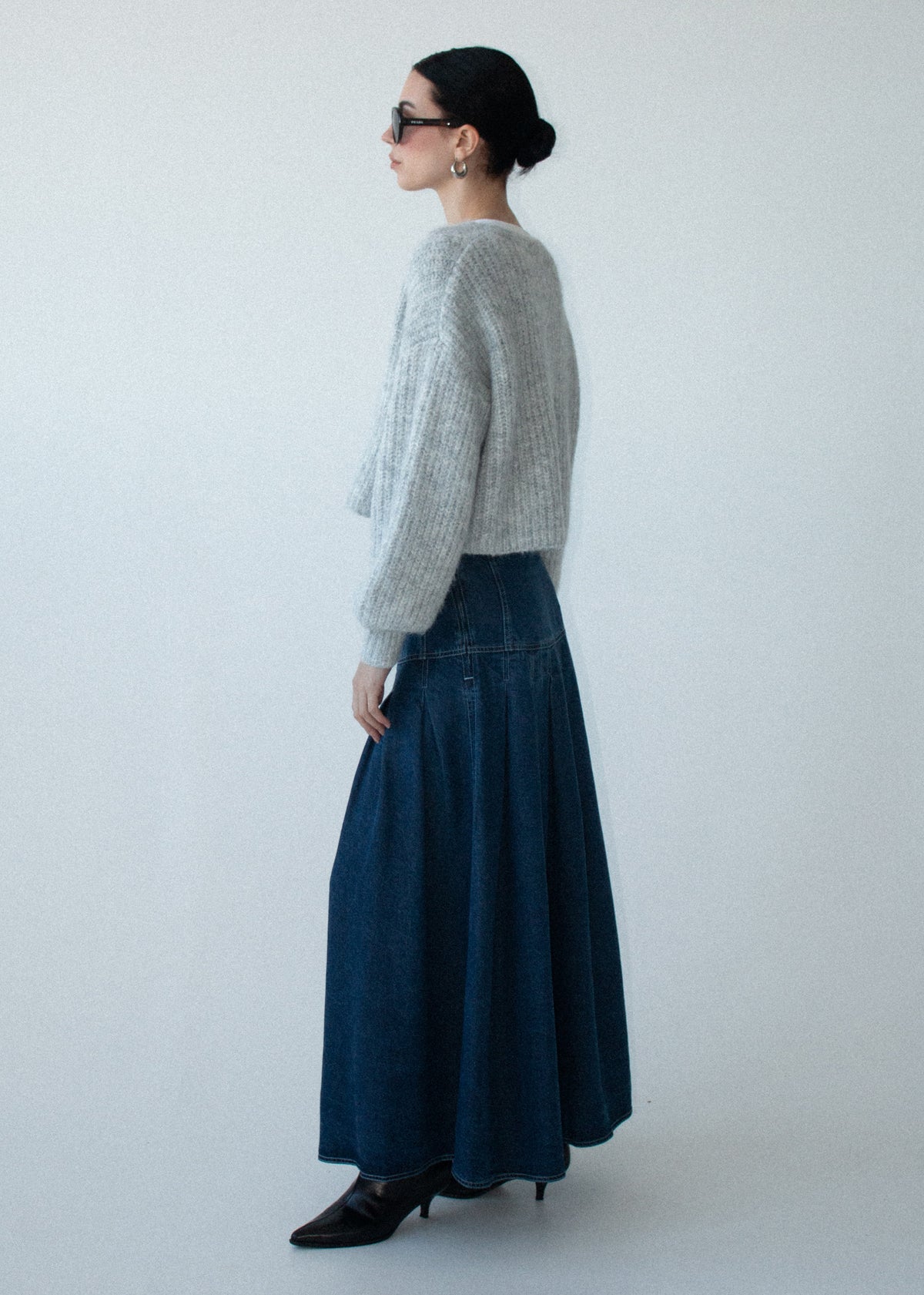 Side view of the Indigo Chambray Box Pleat Midi Skirt, showing a box pleat detail and a full A-line silhouette.