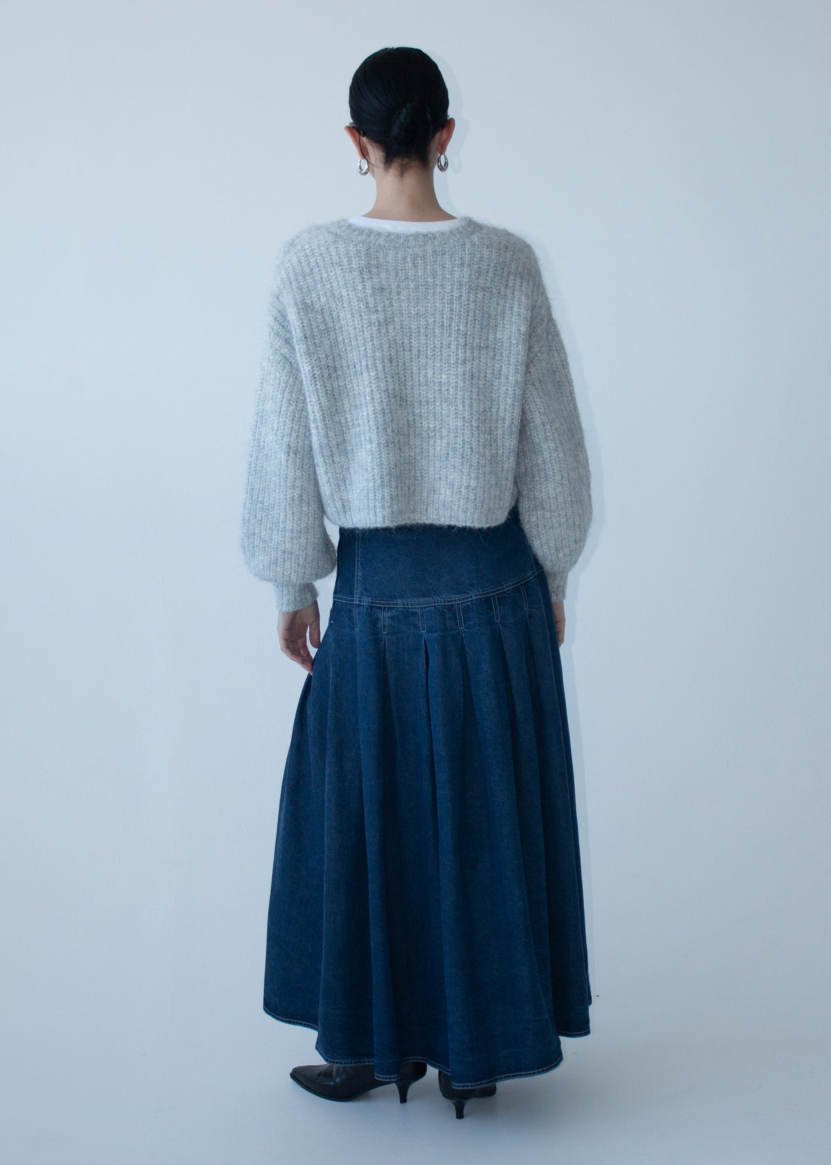 Back view of the Indigo Chambray Box Pleat Midi Skirt with a back zip closure and a mid-weight denim fabrication.