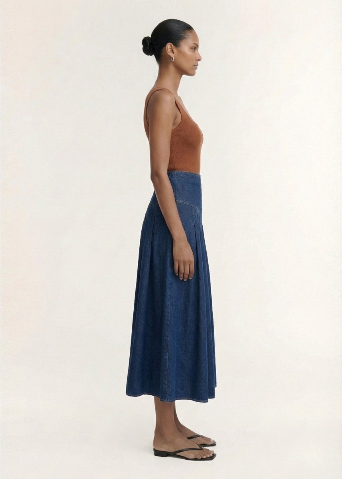 Side profile of the Indigo Chambray Box Pleat Midi Skirt with a box pleat detail and a full A-line silhouette.