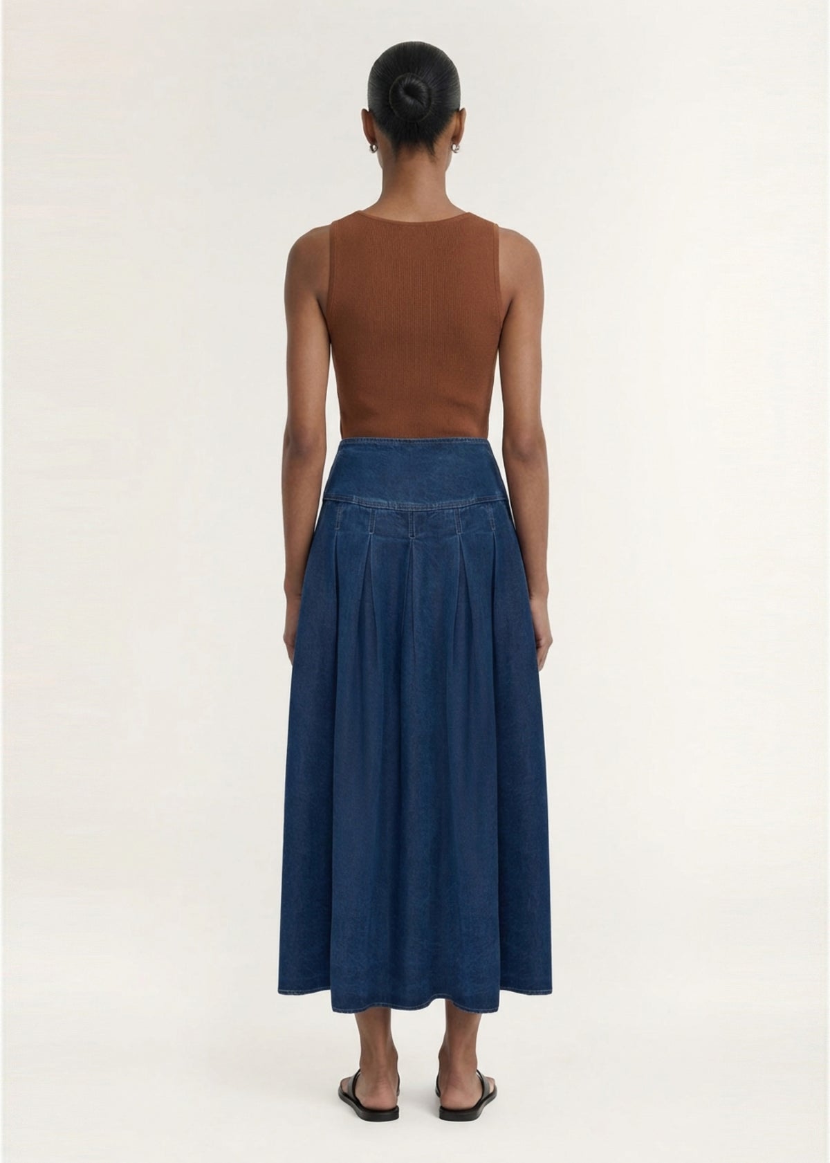 Back view of the Indigo Chambray Box Pleat Midi Skirt, showing a back zip closure and a mid-weight denim fabrication.