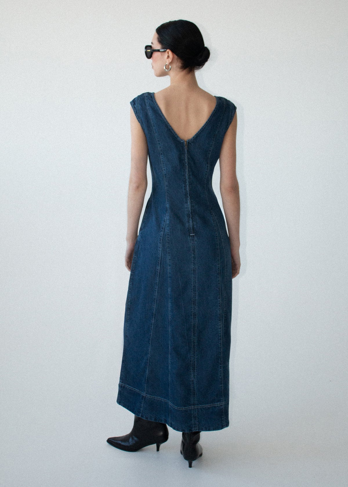 Back view of the Indigo Chambray Panelled Midi Dress with a back zip closure and a mid-weight denim fabrication.