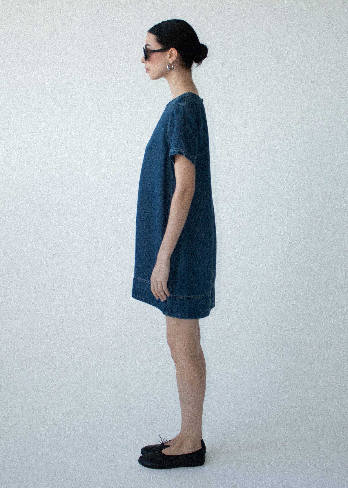 Side view of the Indigo Chambray Short Sleeve Mini Dress, showing a shift silhouette and a back zip closure.