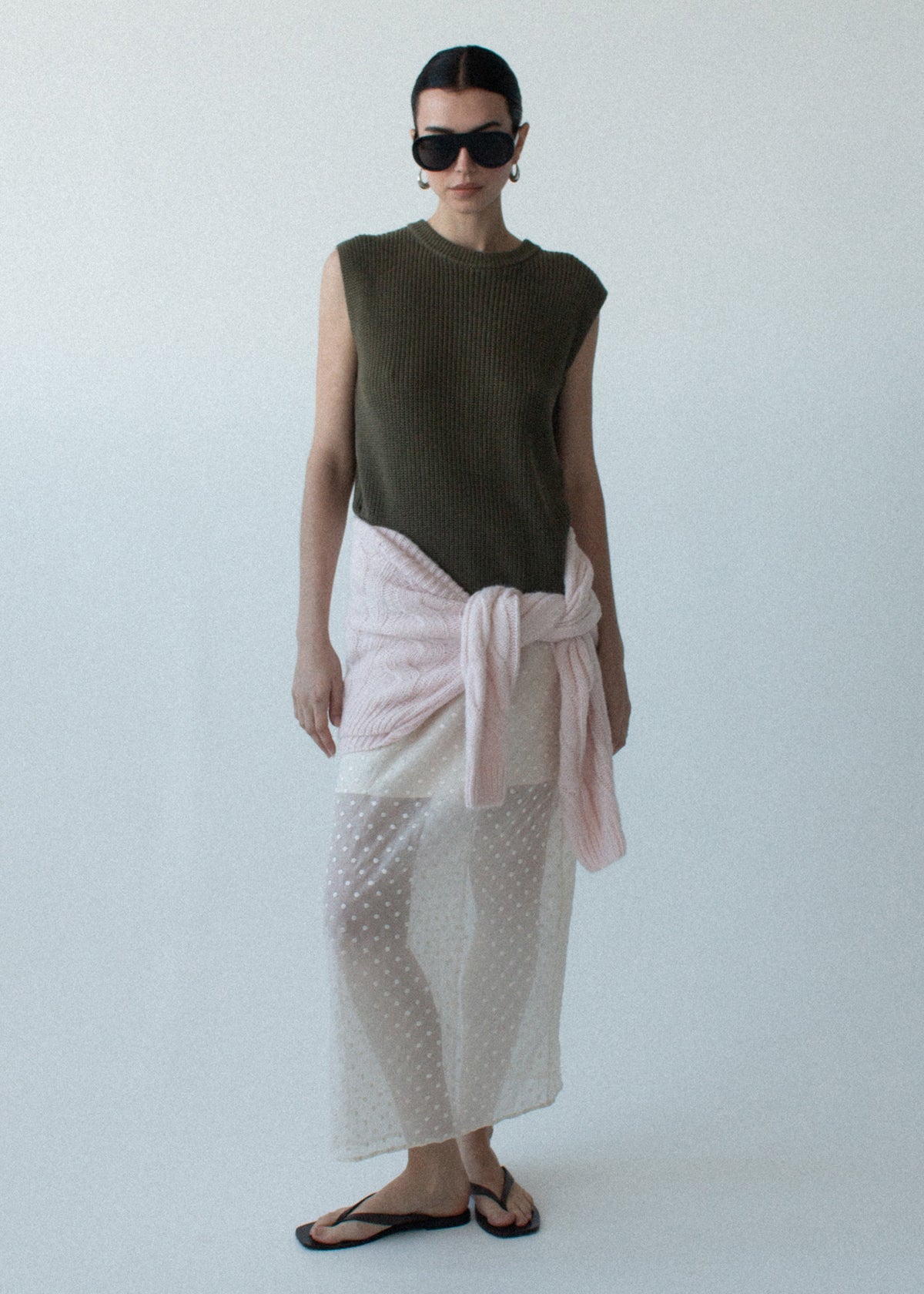 Model wearing Khaki Cotton Blend Knit Tank Top with a ribbed hem and neckline detailing, photographed against a pale blue studio.