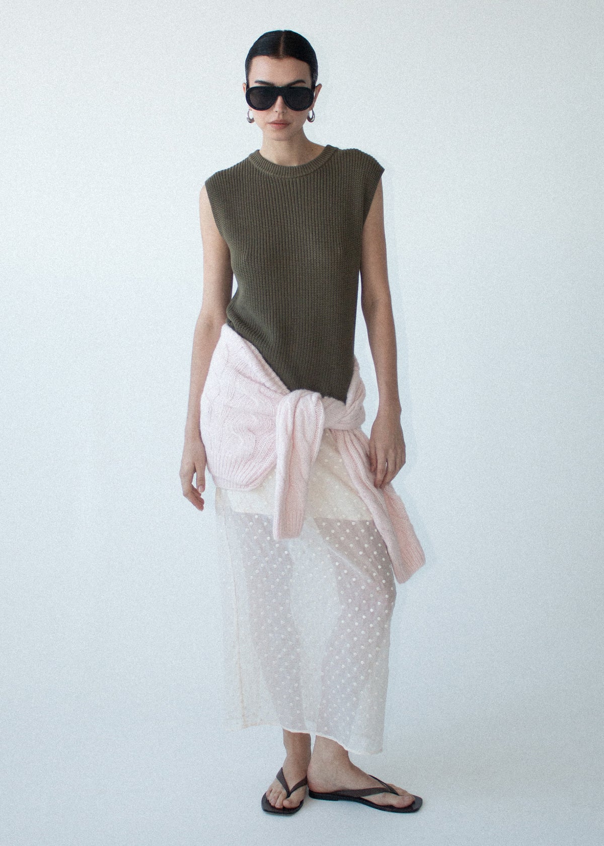 Model wearing Khaki Cotton Blend Knit Tank Top, showing an easy layering essential and a designed, photographed against a pale blue studio.