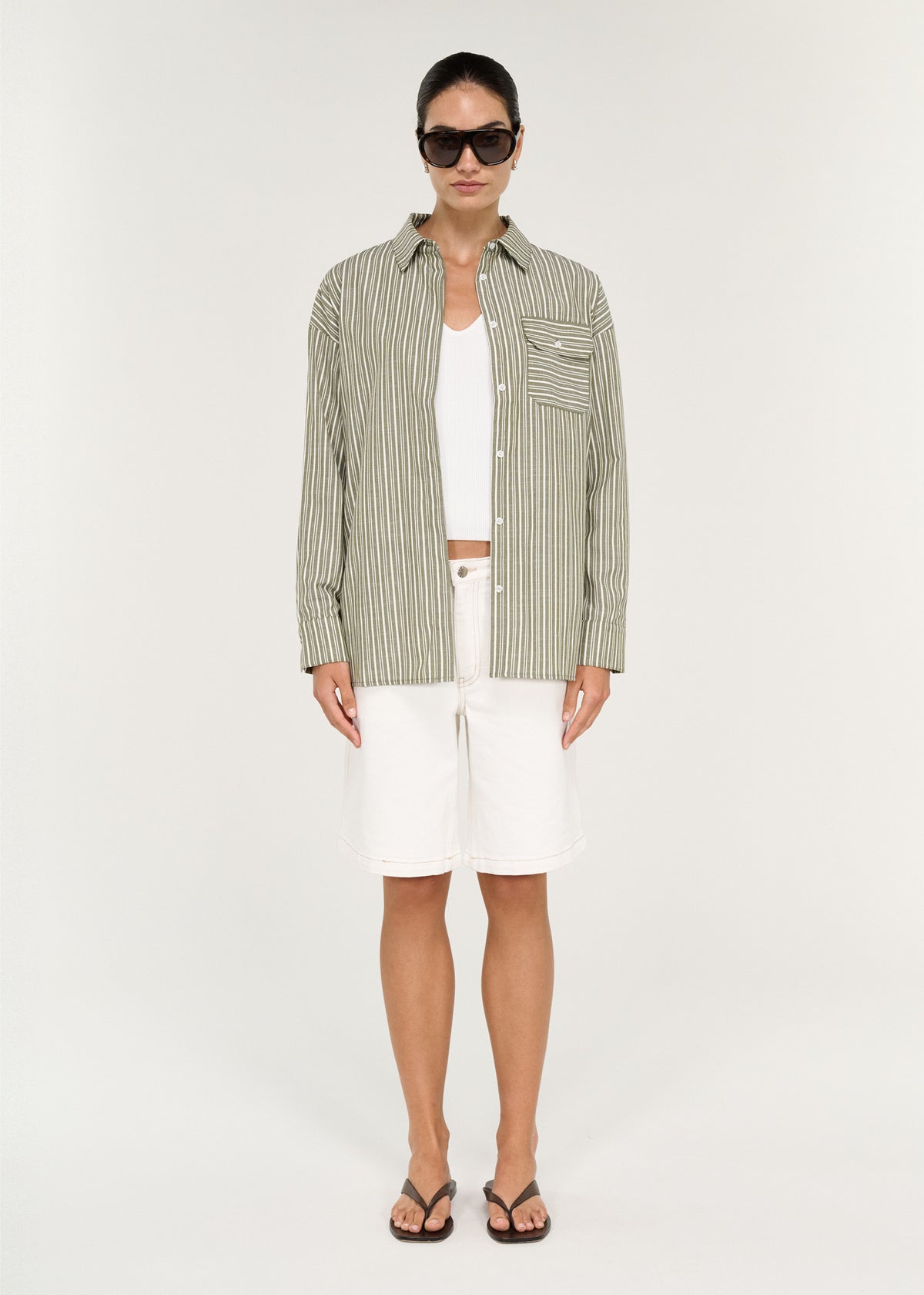 Model wearing Khaki Stripe Cotton Oversized Shirt with a lightweight striped fabrication and an oversized silhouette.