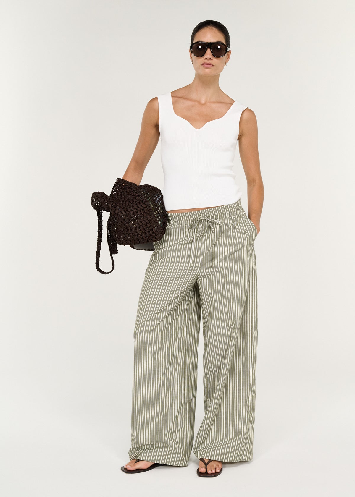 Model wearing Khaki Stripe Relaxed Cotton Pant with a lightweight striped fabrication and a relaxed wide-leg silhouette.