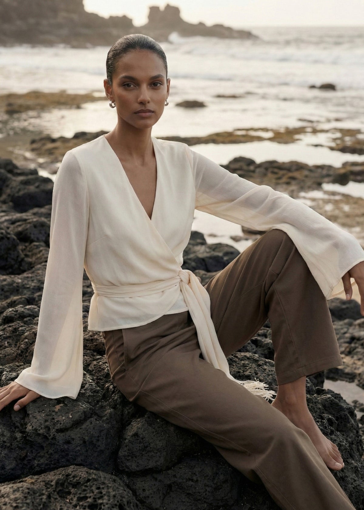 Model seated wearing Khaki Structured Barrel Leg Pant with a relaxed fit through the leg and a cropped ankle length.