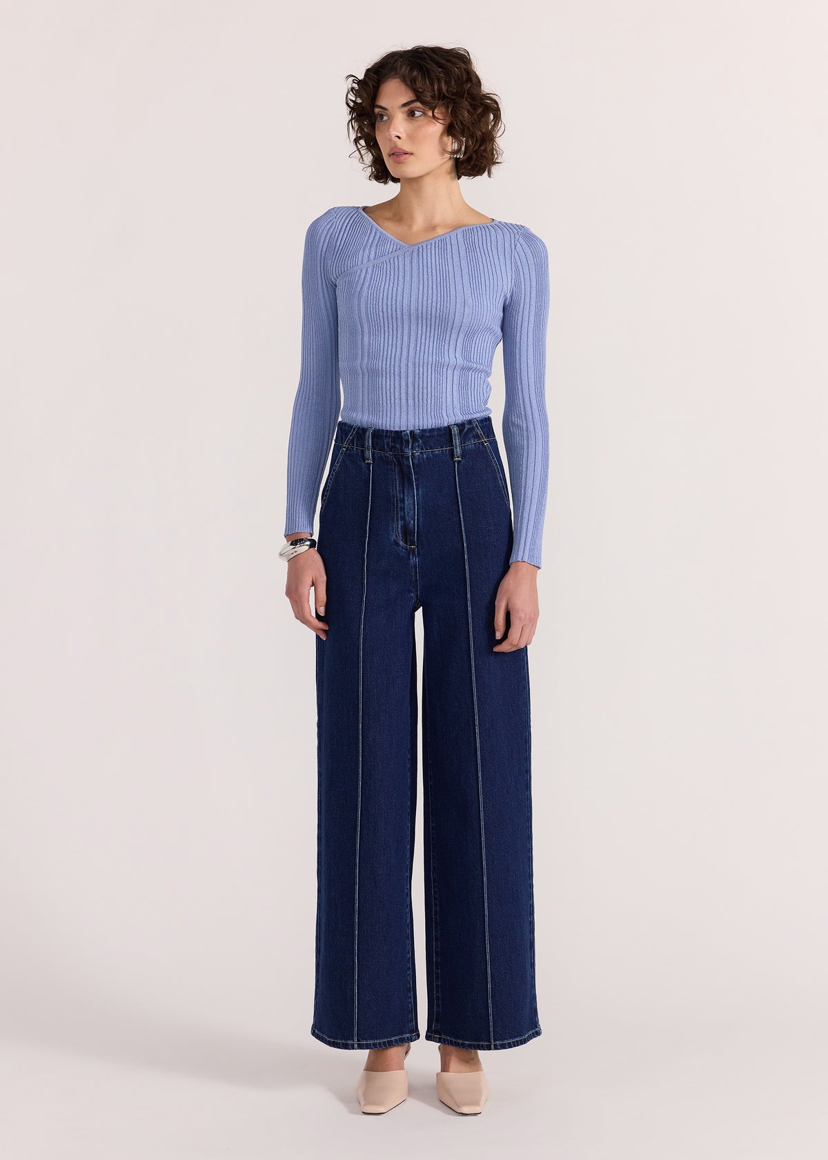 Model wearing Lennox High Waist Jeans with a high-rise waistline with a wide-leg fit and a full-length with vertical front seam detail.