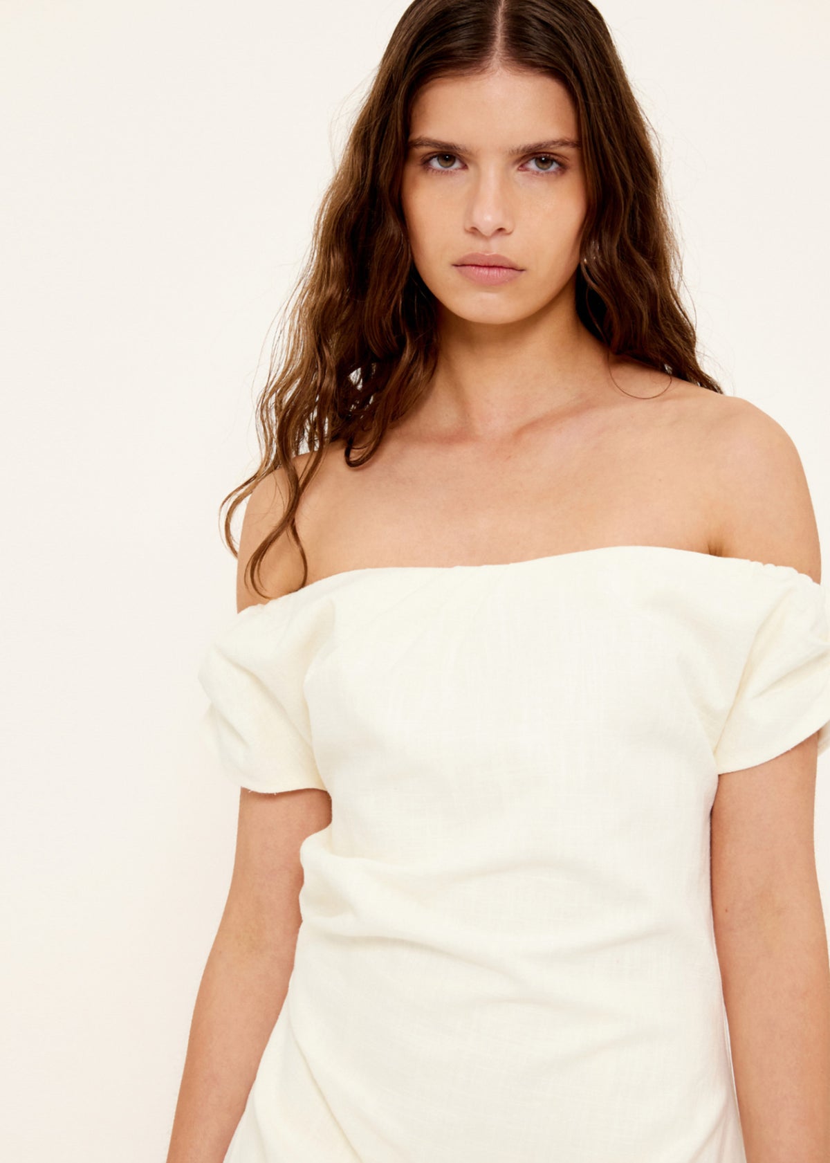 Close-up of the Linen Blend White Off-Shoulder Mini Dress, showing an off-shoulder neckline and a short sleeves with subtle volume.