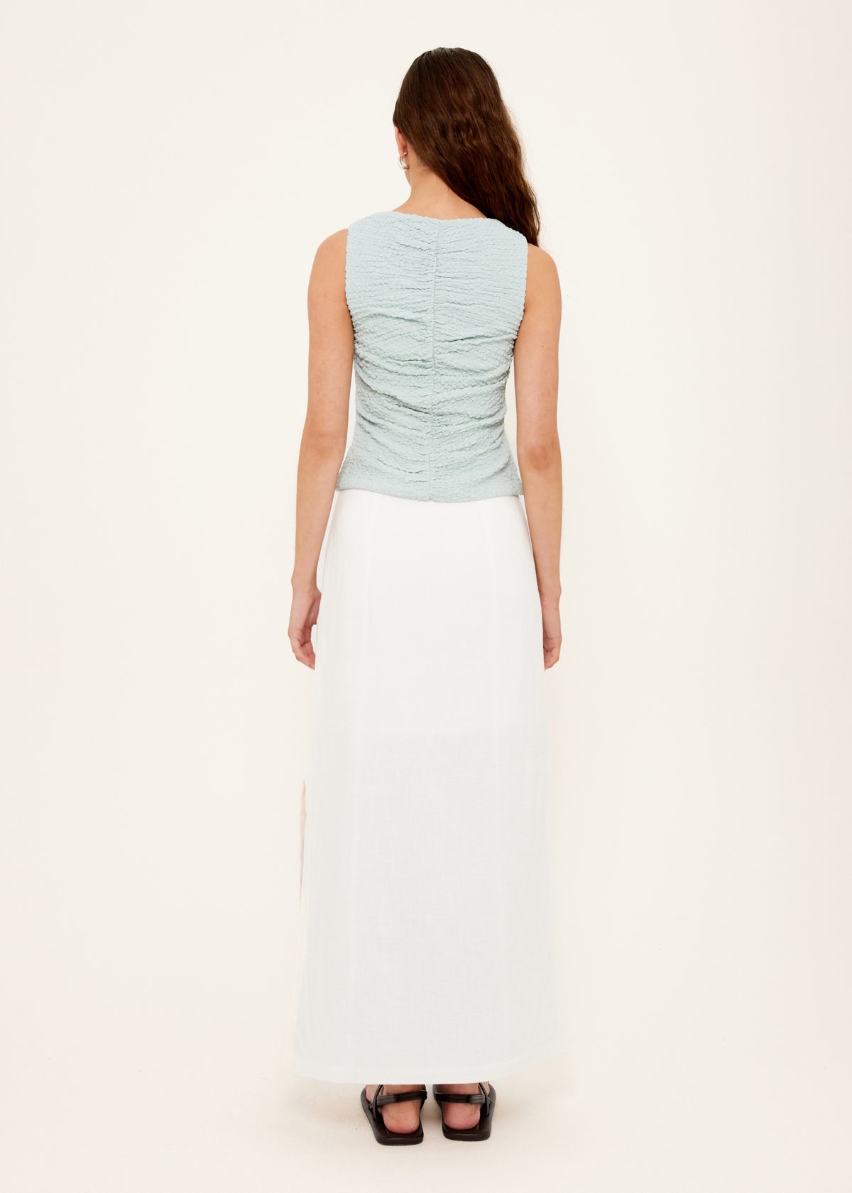 Back view of the Linen Cotton Blend White Midi Skirt with an invisible zip closure at side and a high-waisted, straight cut midi silhouette.