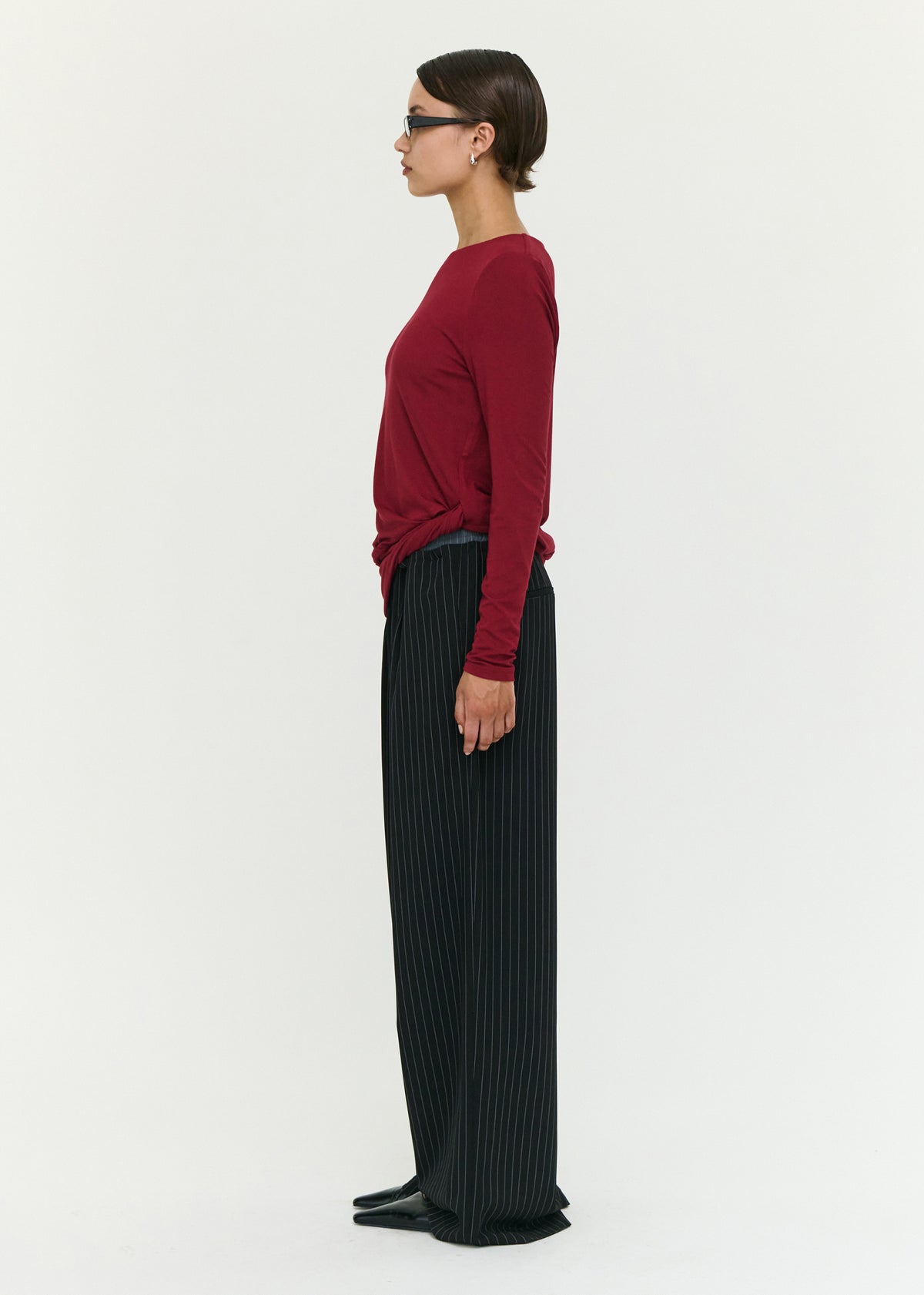 Side view of the Long Sleeve Jersey Twist Top in Merlot, showing a relaxed fit silhouette and a round neckline.
