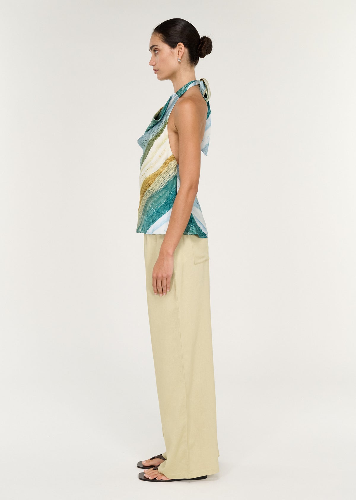 Model wearing Linen Blend Relaxed Pant in Wasabi paired with a colorful top, showcasing a side view of the outfit.