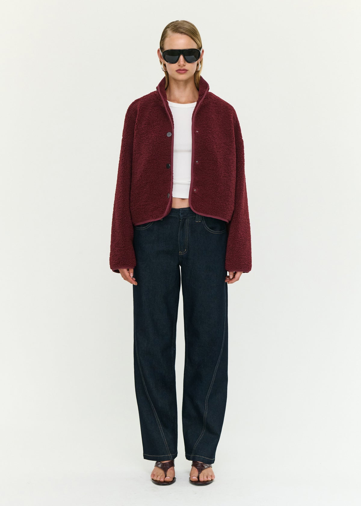 Model wearing Merlot High Neck Cropped Sherpa Jacket, showing a stand collar neckline and a snap button front closure.