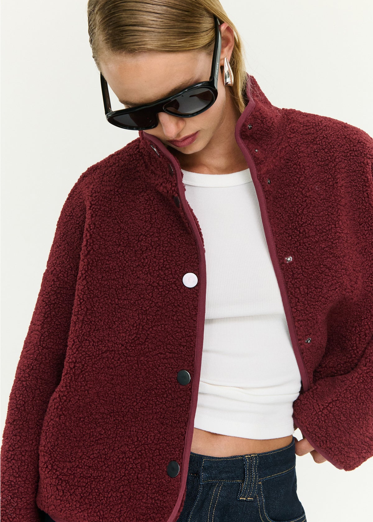 Close-up of the Merlot High Neck Cropped Sherpa Jacket, showing a stand collar neckline and a snap button front closure.