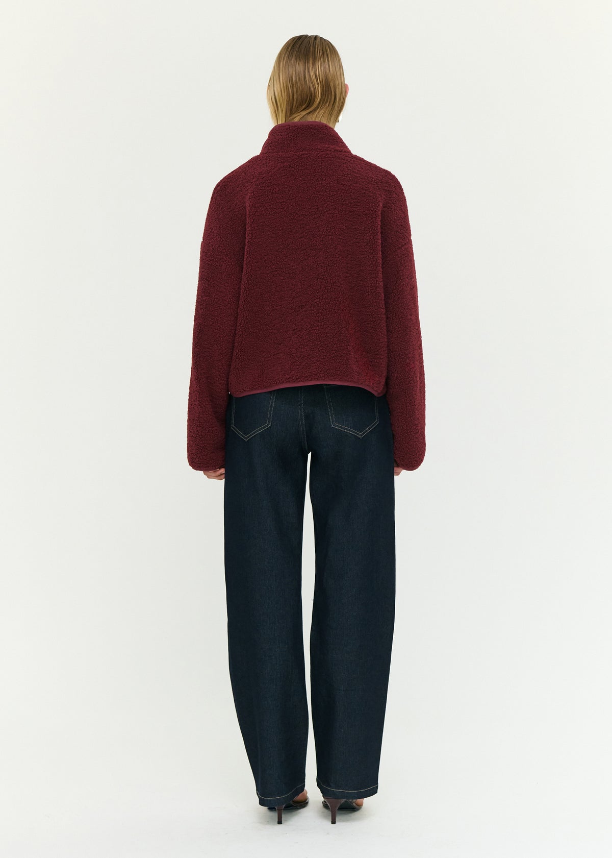 Back view of the Merlot High Neck Cropped Sherpa Jacket with a snap button front closure and a soft sherpa fabrication.