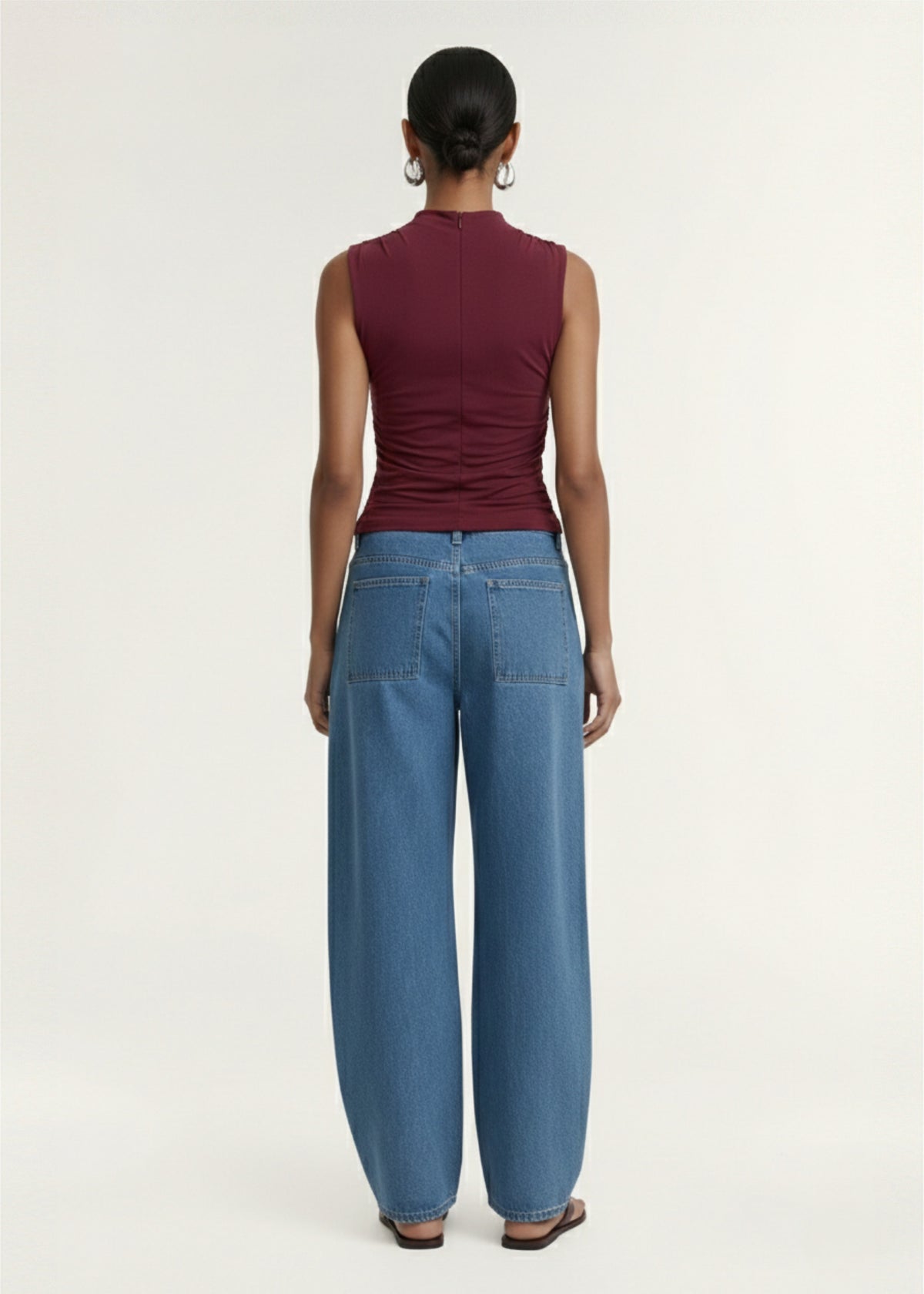 Back view of the Mid Blue Barrel Leg Denim Jeans with a zip fly with button closure and a mid-wash denim fabrication.