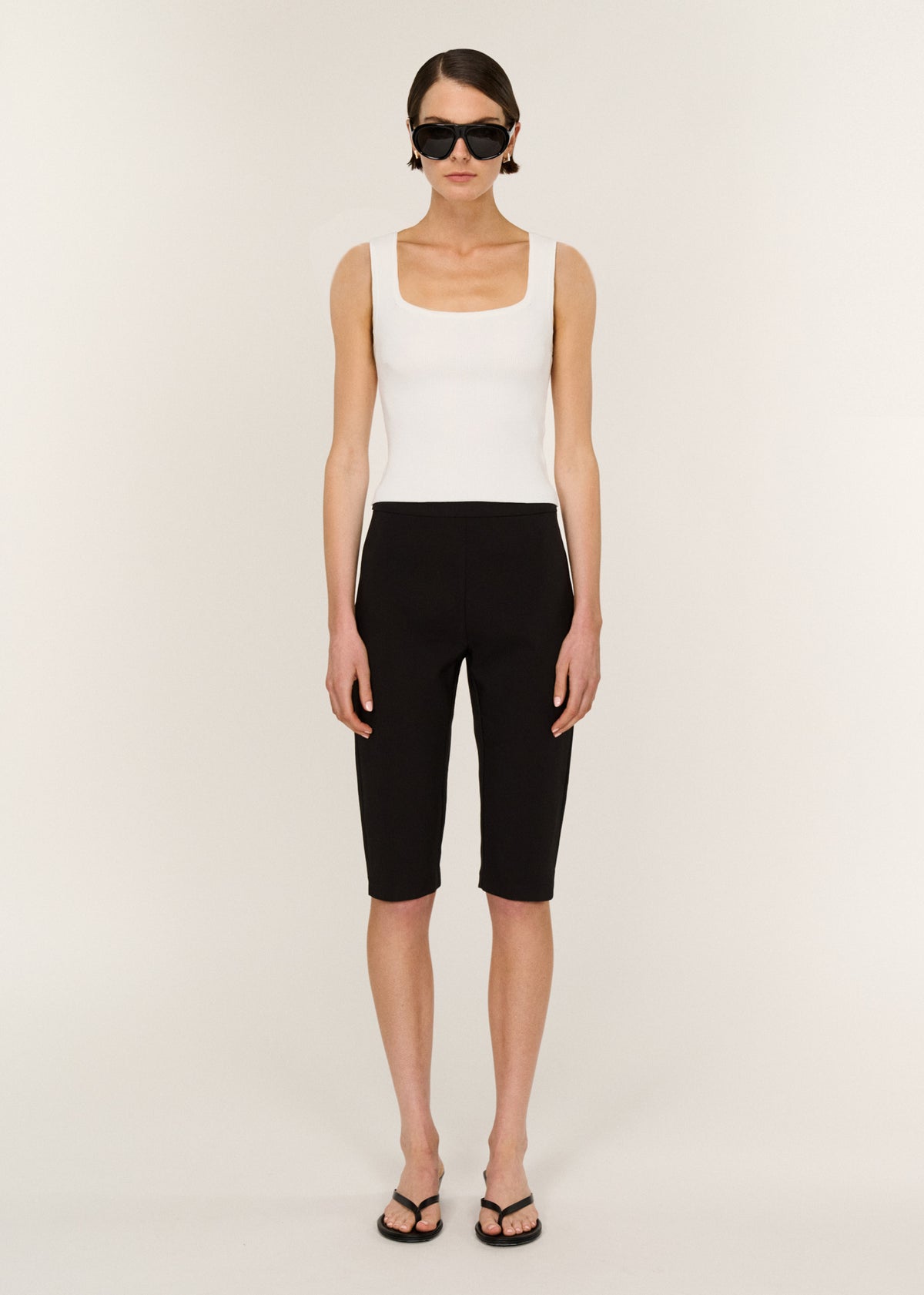 Model wearing Mid Rise Capri Pants in Black with a high-rise waist and a clean waistband.