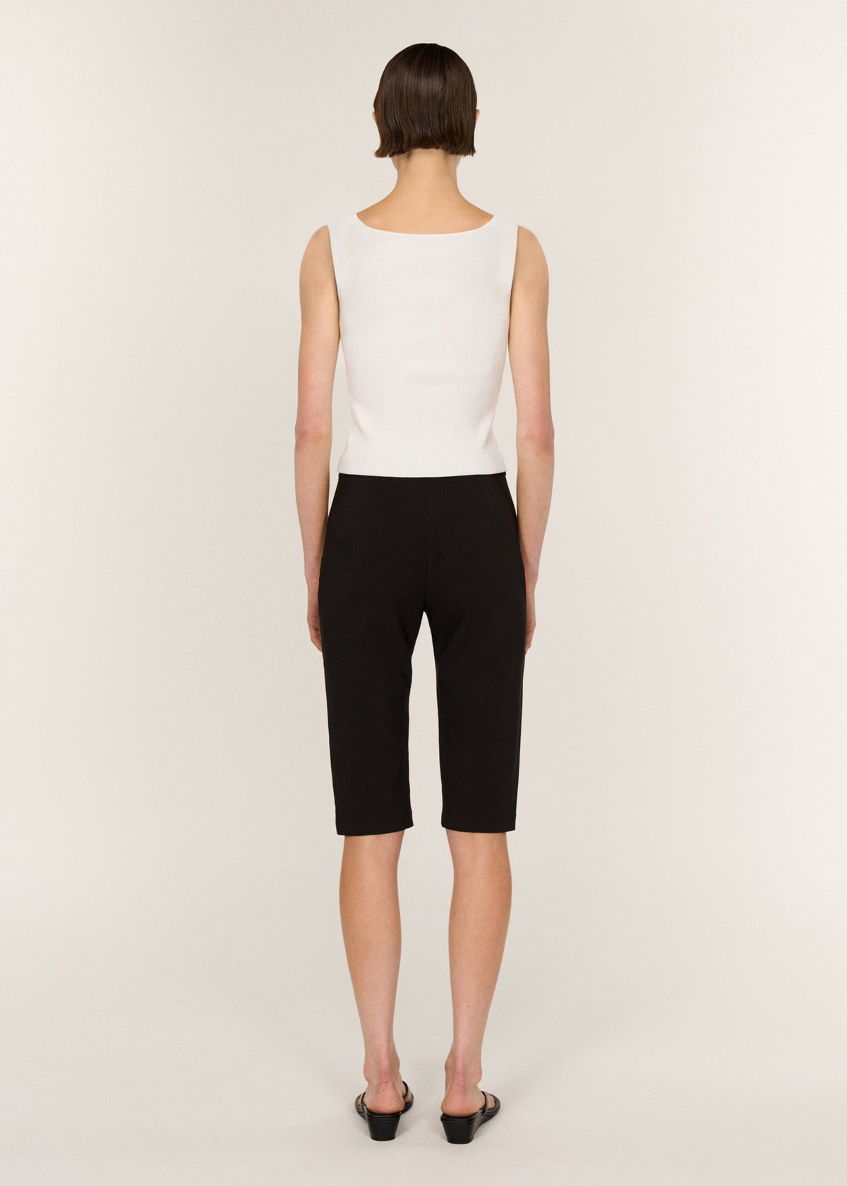 Back view of the Mid Rise Capri Pants in Black with a side zip closure and a high-rise waist.