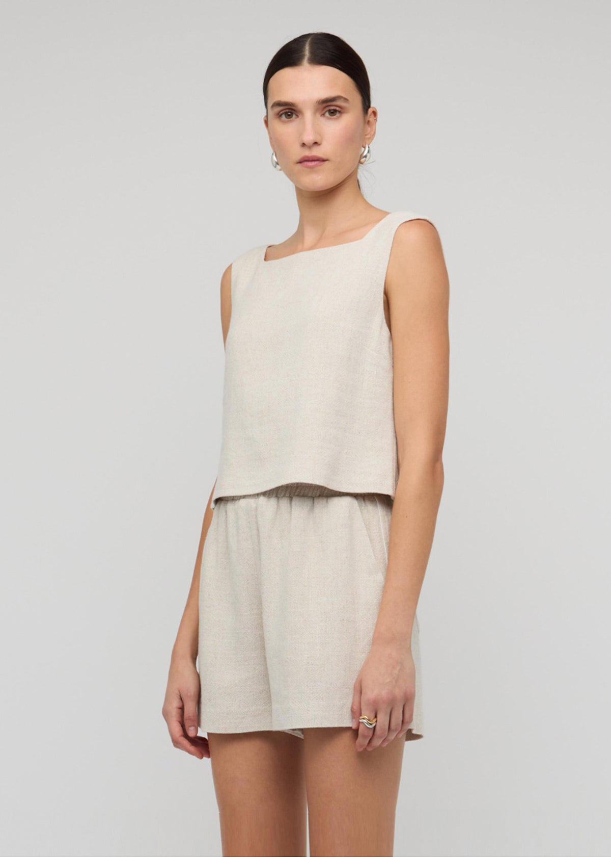Model wearing Natural Marle Relaxed Linen Shorts with side and back pockets.
