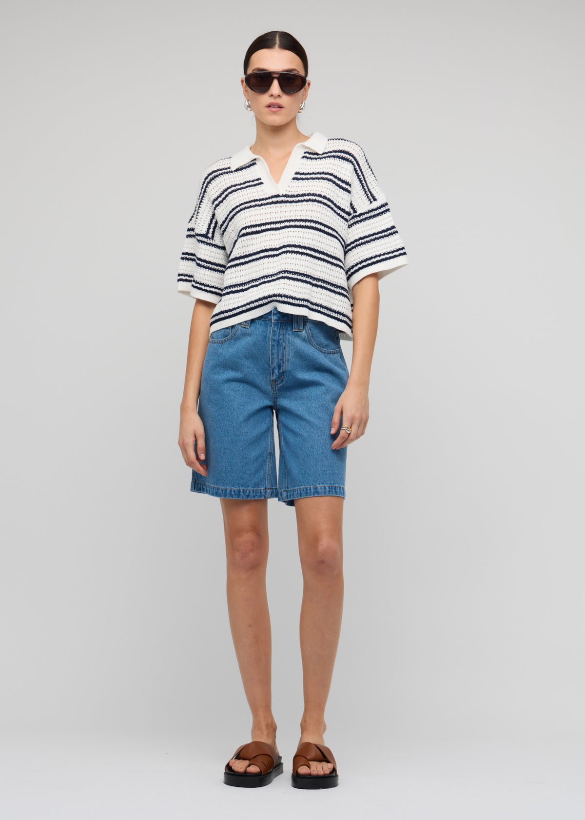 Model wearing Navy and White Knit Polo Top with a short sleeves with drop shoulder and an open V-neckline.