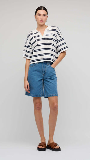 Model wearing a Navy & White Knit Polo Top with denim shorts, showcasing a modern summer look.