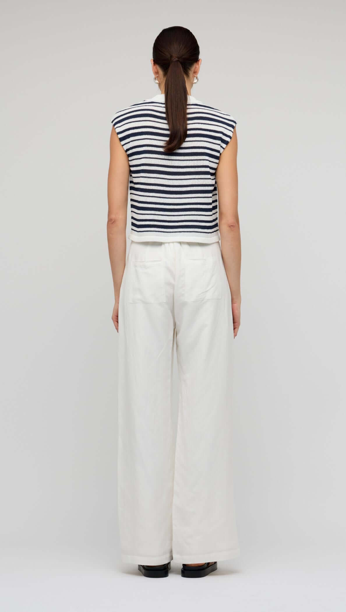 Back view of woman wearing a Navy & White Stripe Knit Tank Top with wide-leg pants.