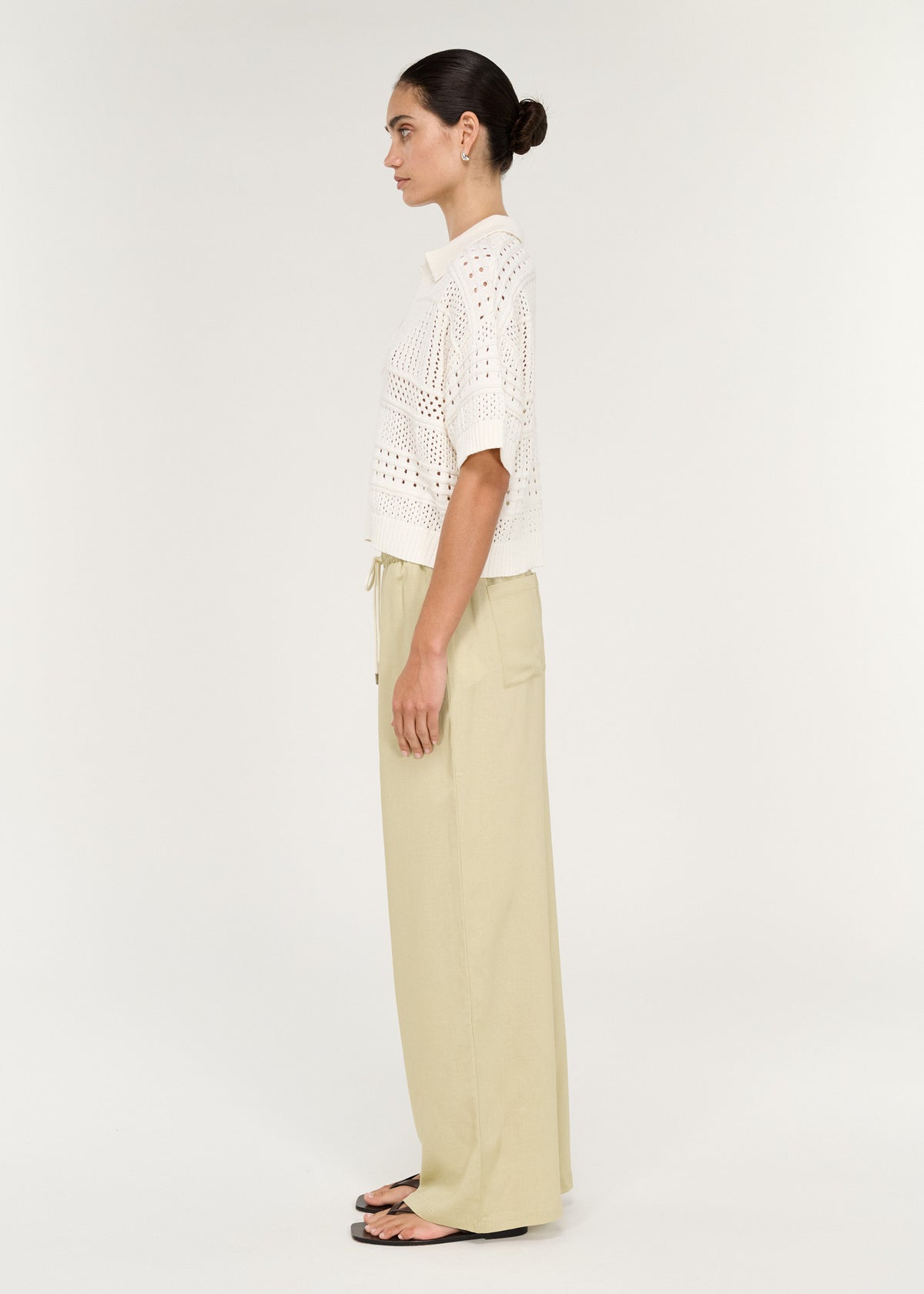 Relaxed Crochet Polo Shirt in Cream modeled with light green pants, showcasing a side view and trendy summer look.