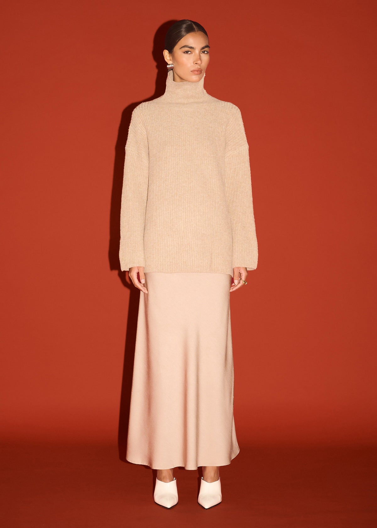 Model wearing Oatmeal Roll Neck Oversized Knit Jumper with dropped shoulder seams and a ribbed knit texture.