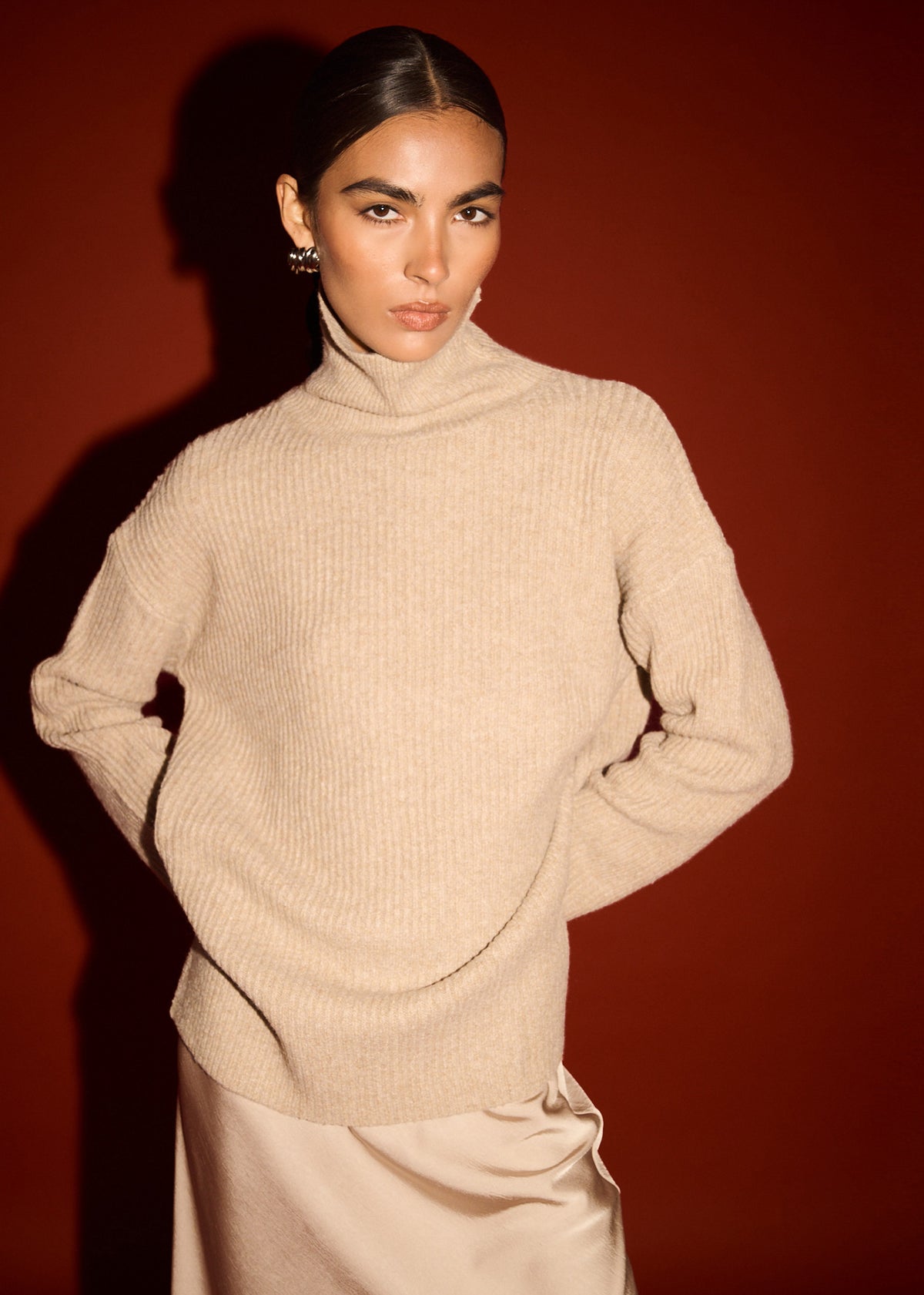 Close-up of Oatmeal Roll Neck Oversized Knit Jumper with a roll neck neckline and dropped shoulder seams.