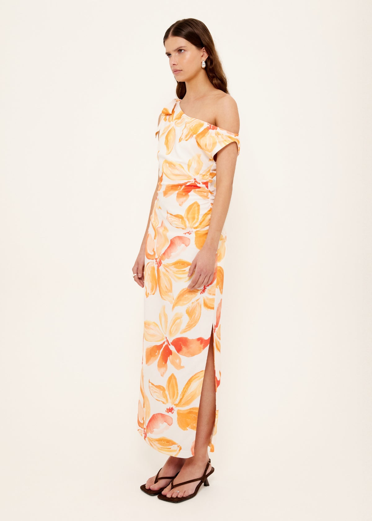 Model wearing Orange and White Floral Asymmetric Midi Dress with an invisible side zip closure and a fully lined, turned to the side.