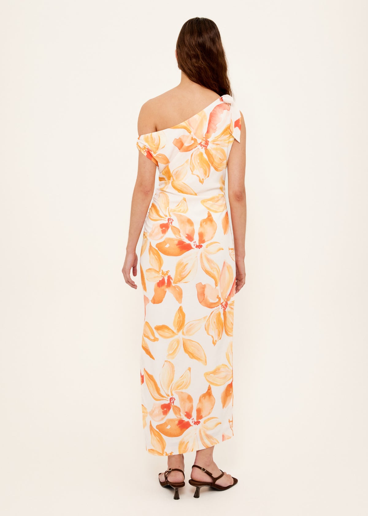 Back view of the Orange and White Floral Asymmetric Midi Dress with an invisible side zip closure and an exclusive Staple floral print.