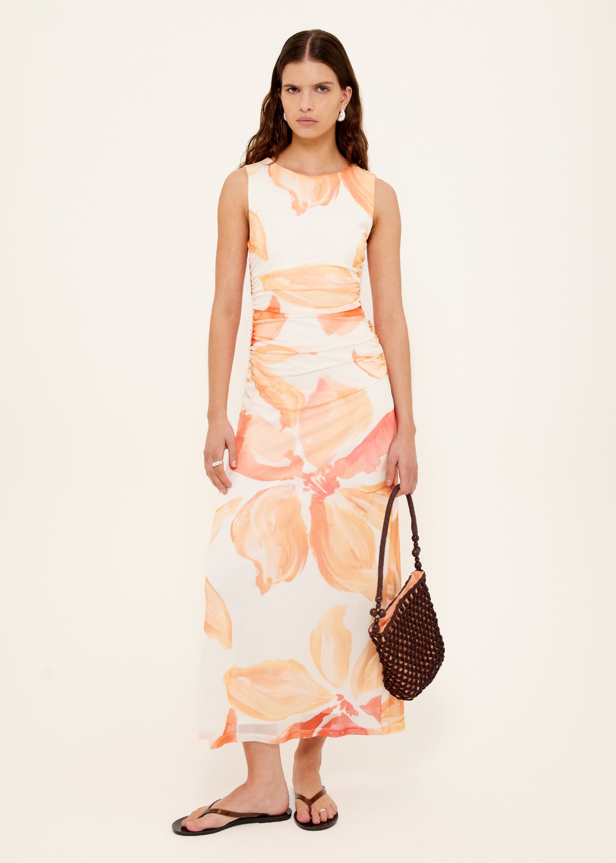 Model wearing Orange and White Floral Mesh Midi Dress with a soft mesh fabrication and abstract floral print in warm peach tones.