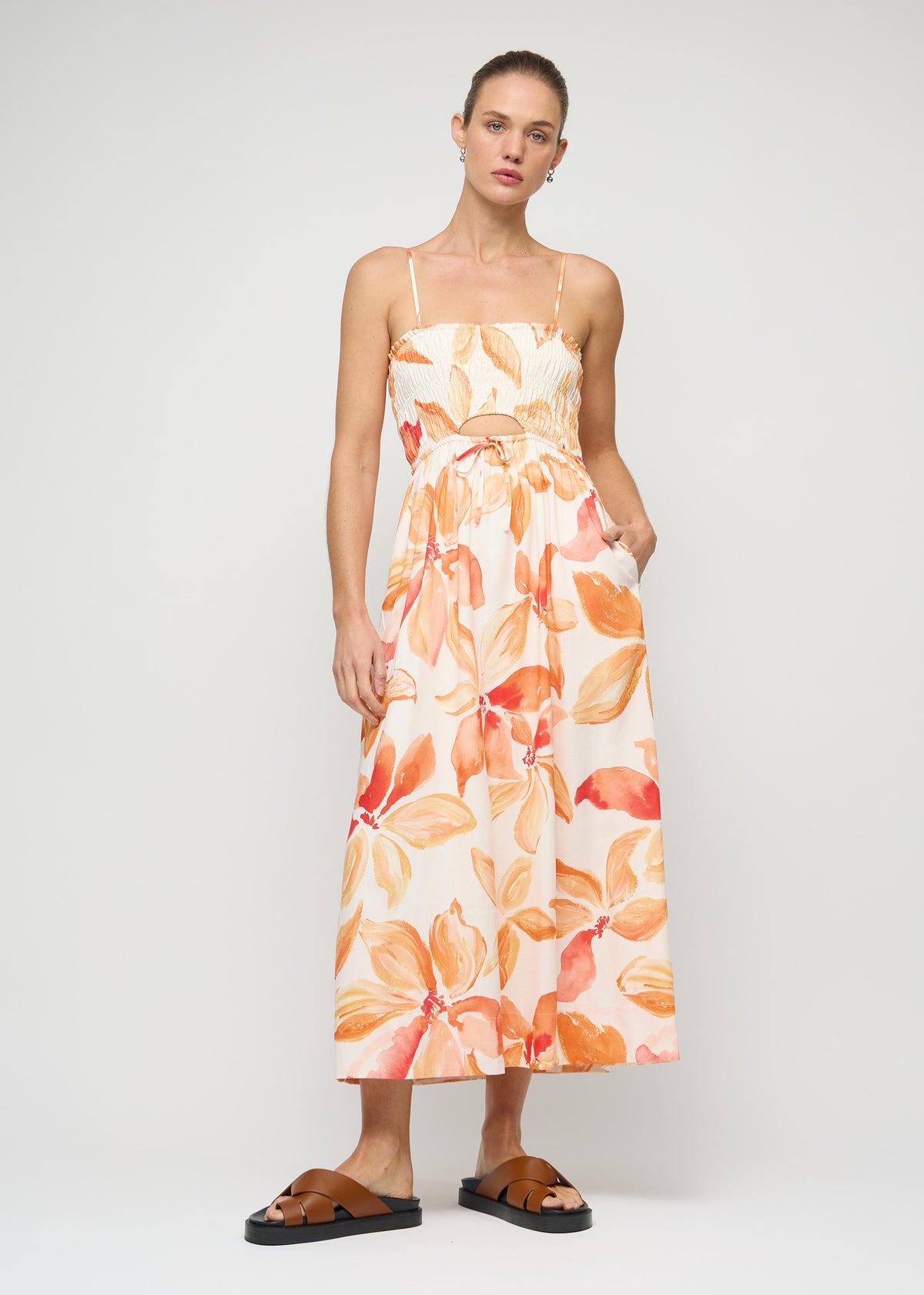 Model wearing Orange and White Floral Shirred Midi Dress, showing a cut-out waist detail and a fully lined.