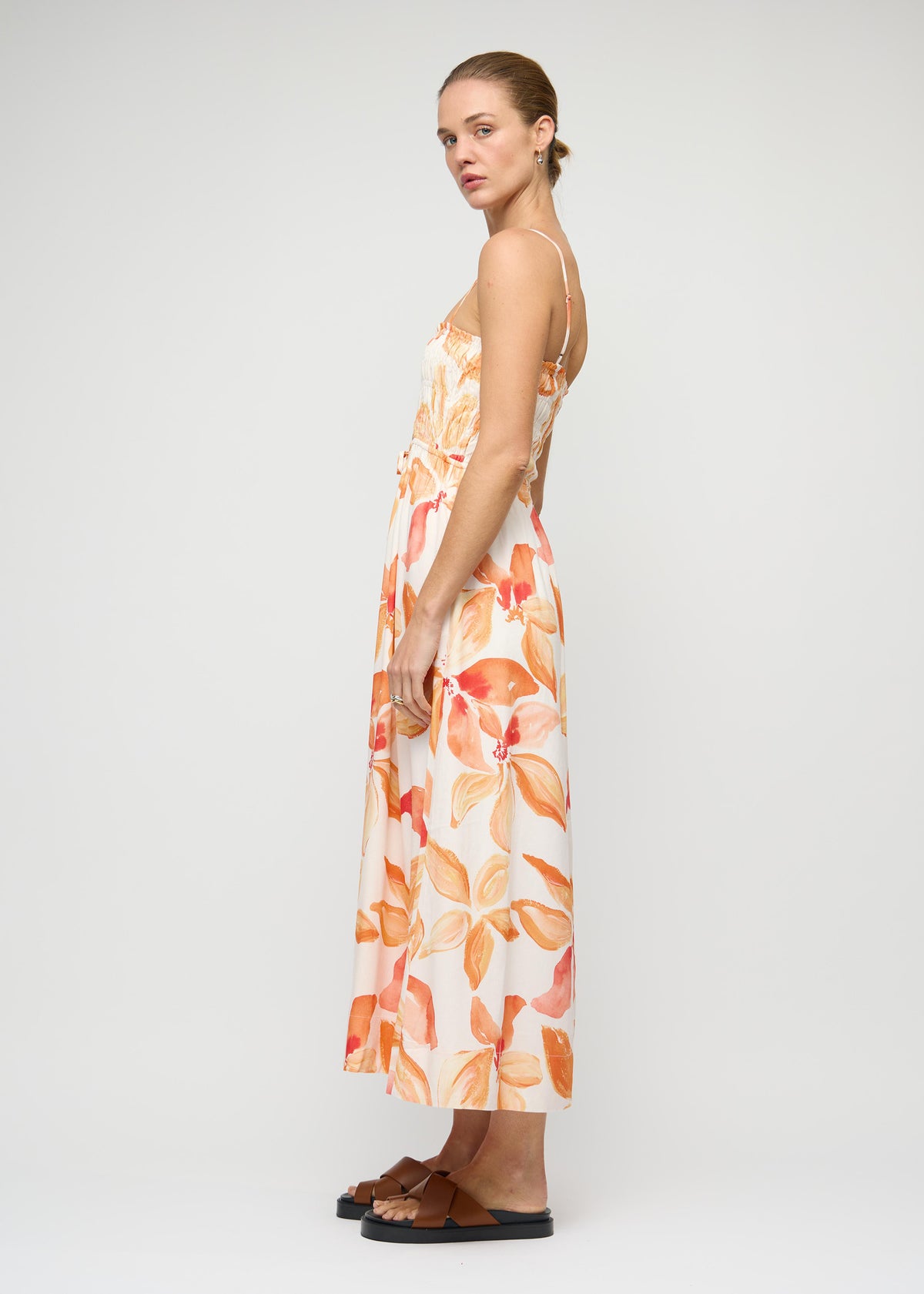 Side view of the Orange and White Floral Shirred Midi Dress, showing a cut-out waist detail and a fully lined.