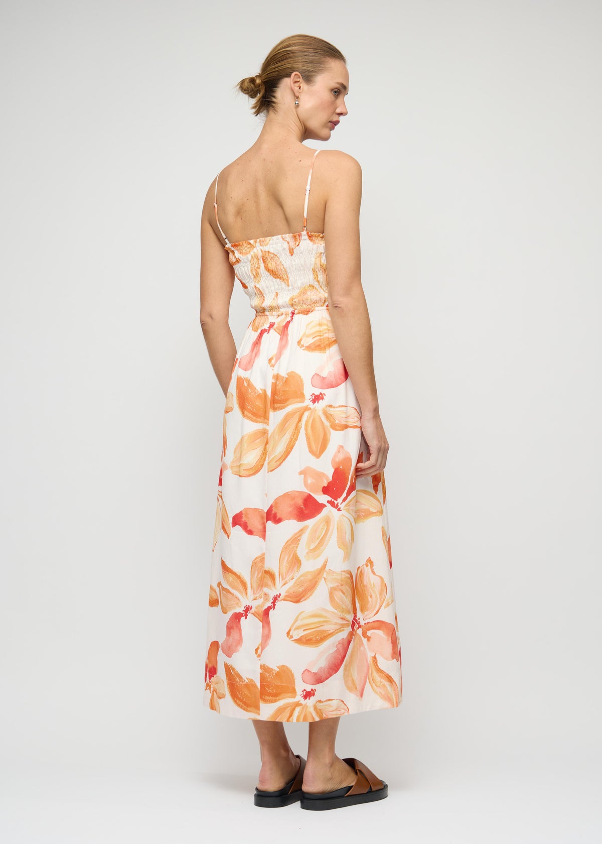 Back view of the Orange and White Floral Shirred Midi Dress with shirred bodice with adjustable straps and an exclusive Staple floral print.