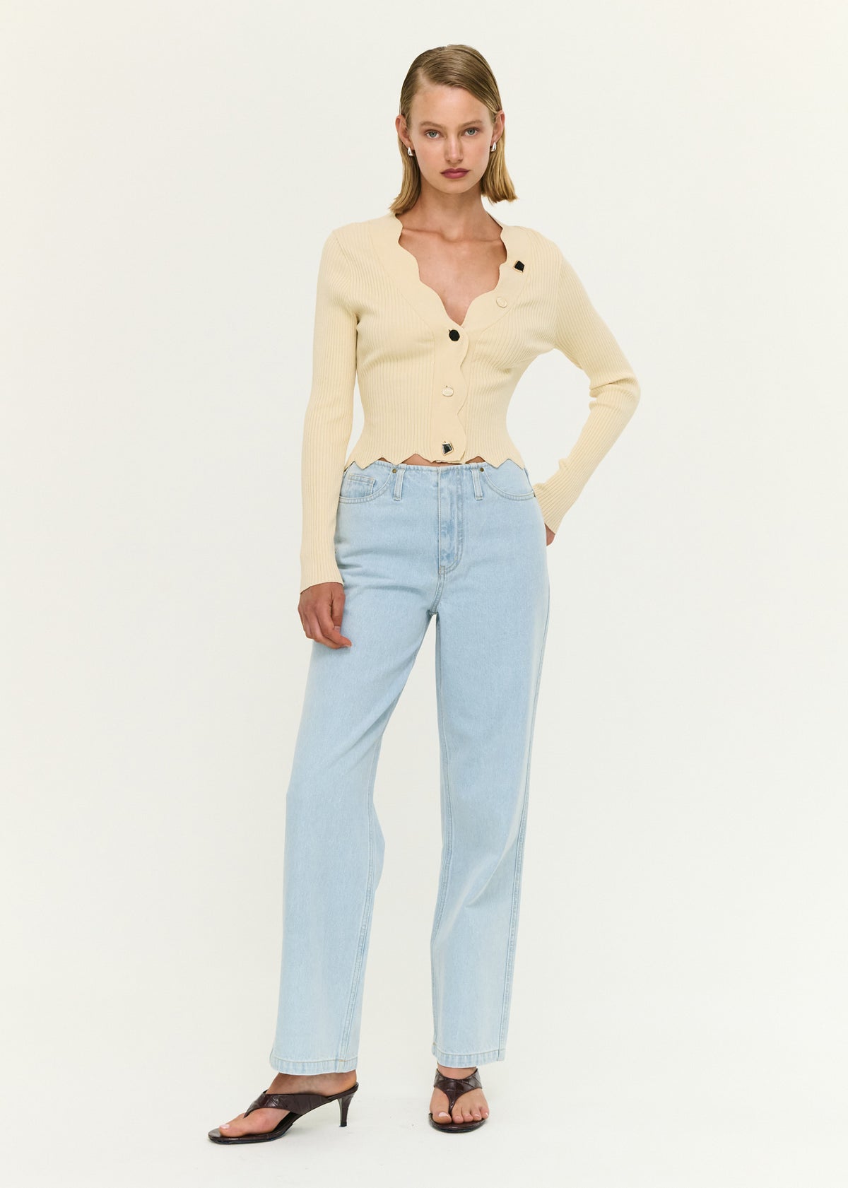 Model wearing Ornate Button Scallop Neck Cardigan in Yellow with a soft ribbed knit fabrication and a cropped length.