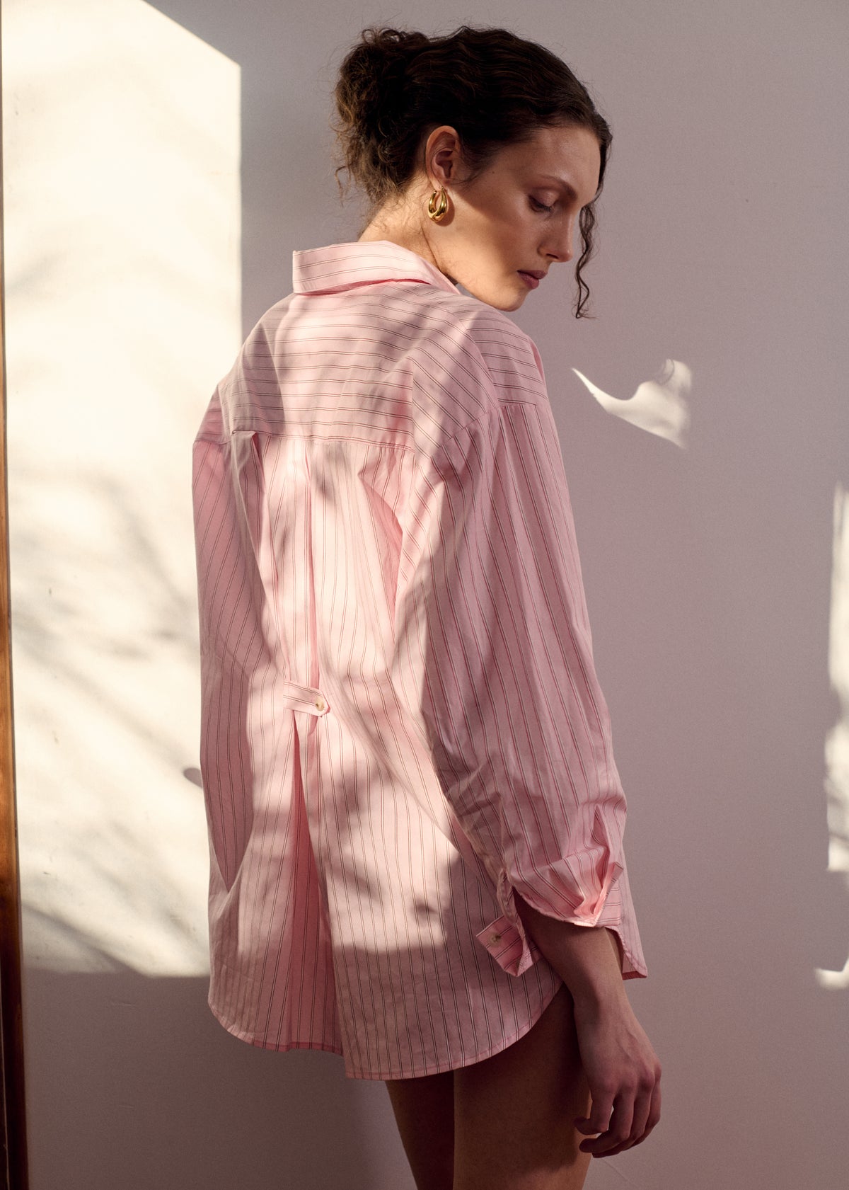 Back view of the Oversized Cotton Shirt with Back Button Detail with a button-through front and long sleeves with button cuffs.
