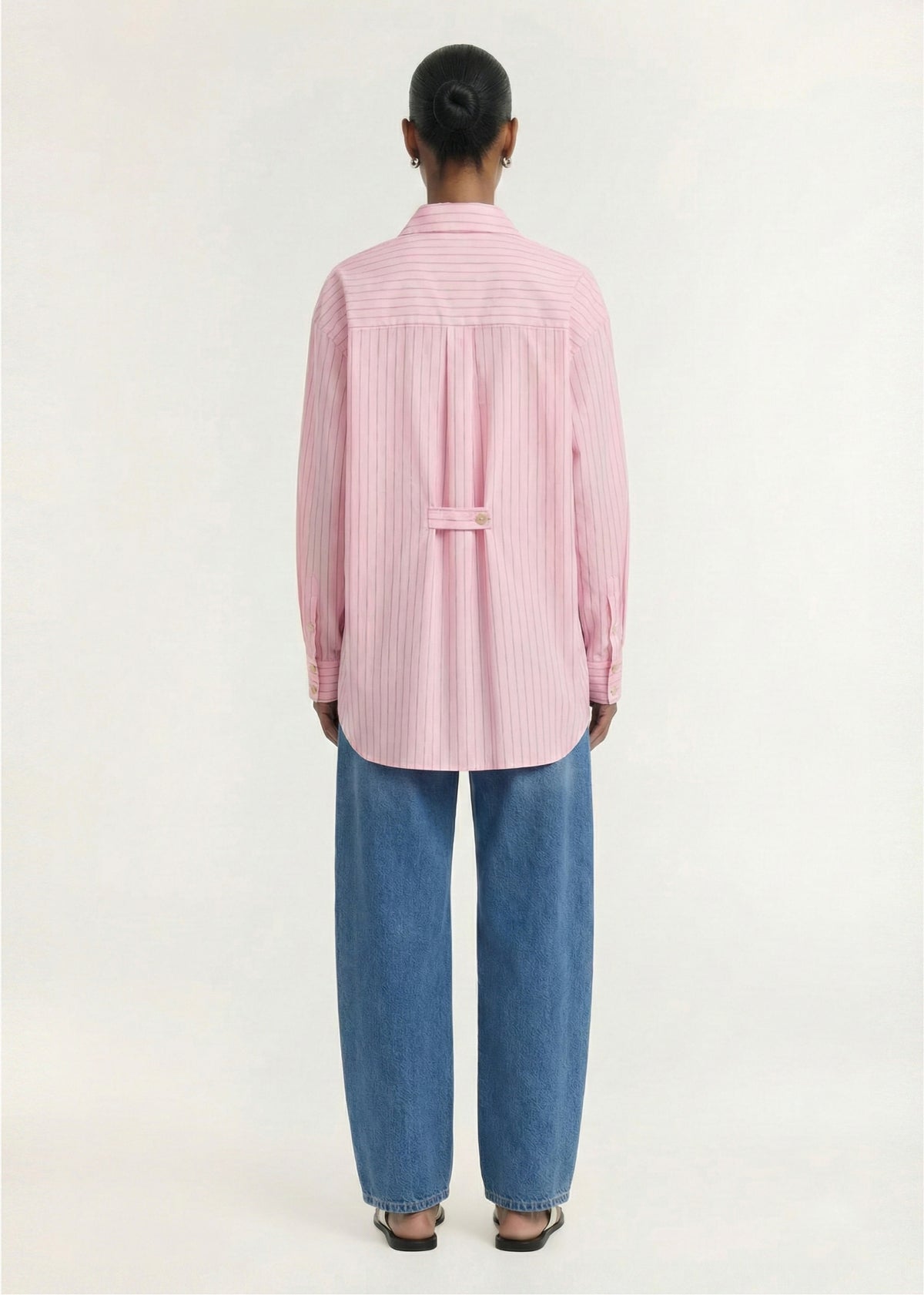 Back view of the Oversized Cotton Shirt with Back Button Detail, showing a button-through front and long sleeves with button cuffs.