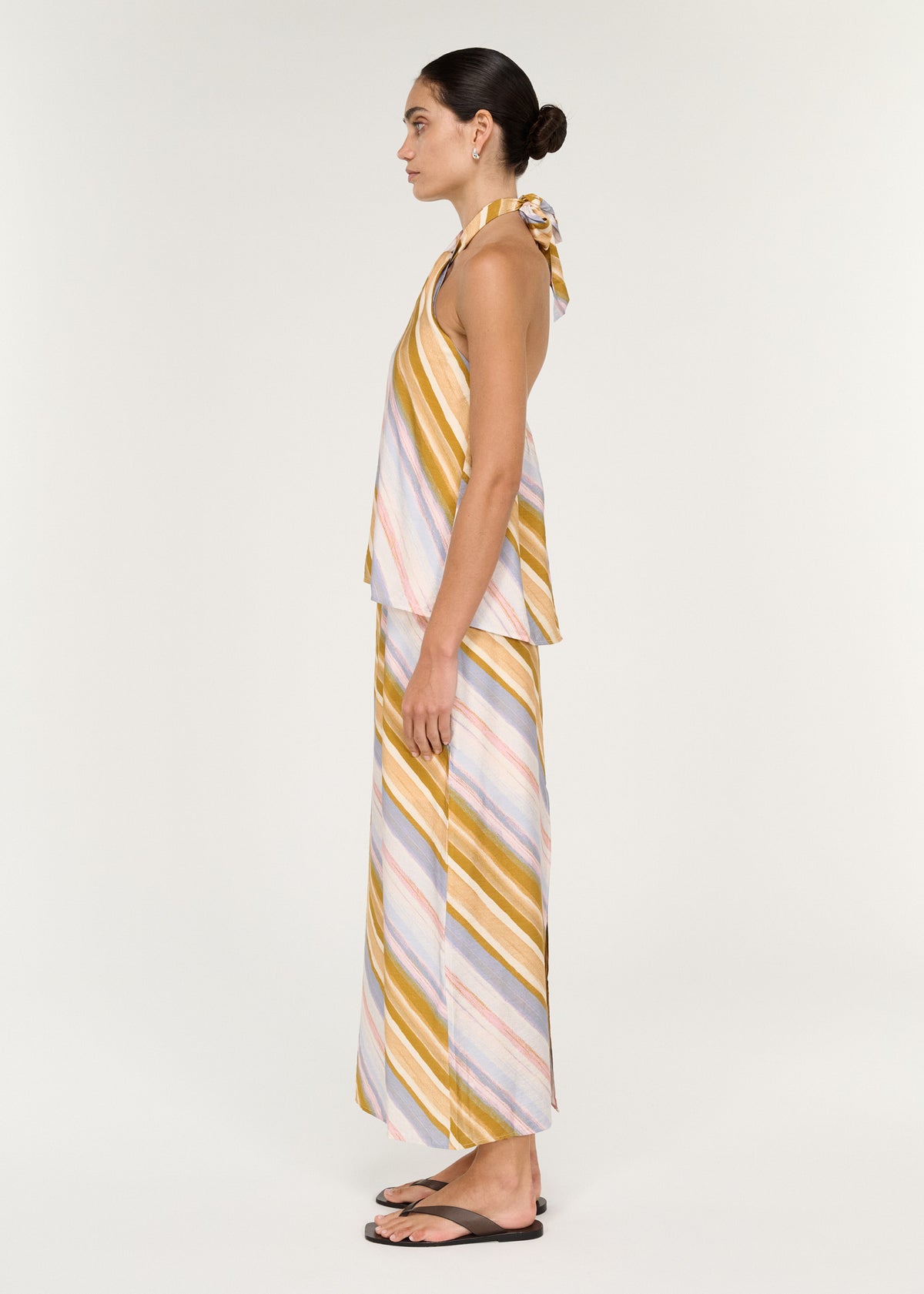 Side view of the Pastel Stripe Mid Rise Midi Skirt, showing a back split and a painterly diagonal stripe print.