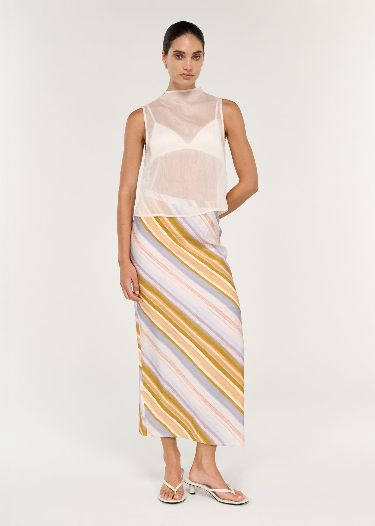 Model wearing Pastel Stripe Mid Rise Midi Skirt, showing a painterly diagonal stripe print and a midi length.