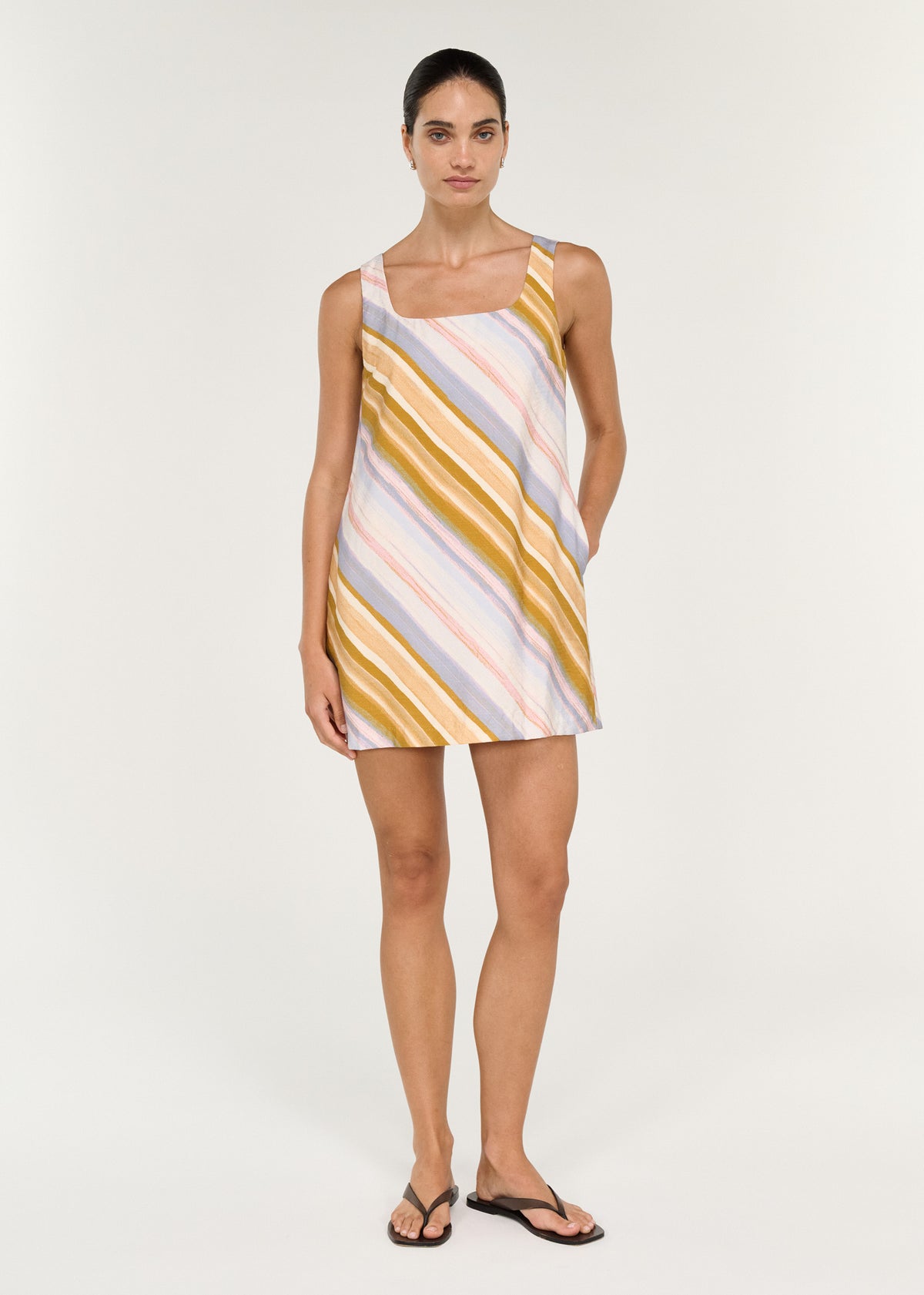 Model wearing Pastel Stripe Square Neck Mini Dress with wide shoulder straps and side pockets.